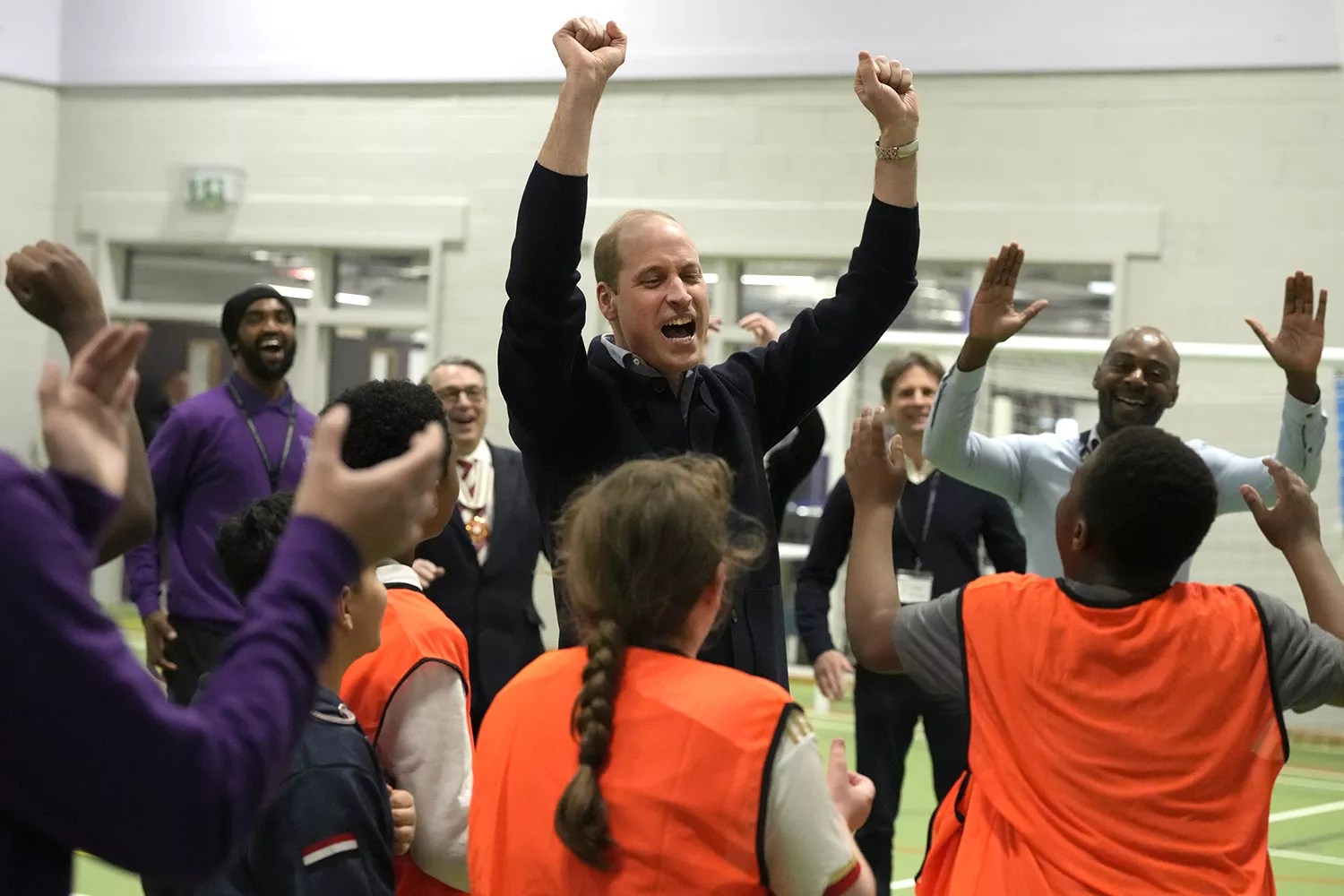 Prince William, Prince Of Wales celebrates with young people after he threw a basketball during his visit to WEST, a new OnSide Youth Zone WEST
