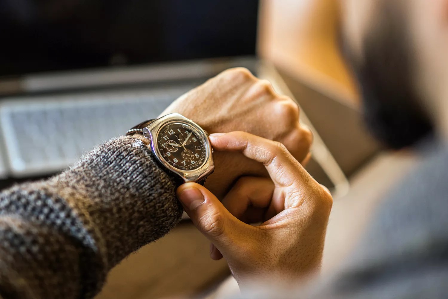 Young freelancer checking time while working.