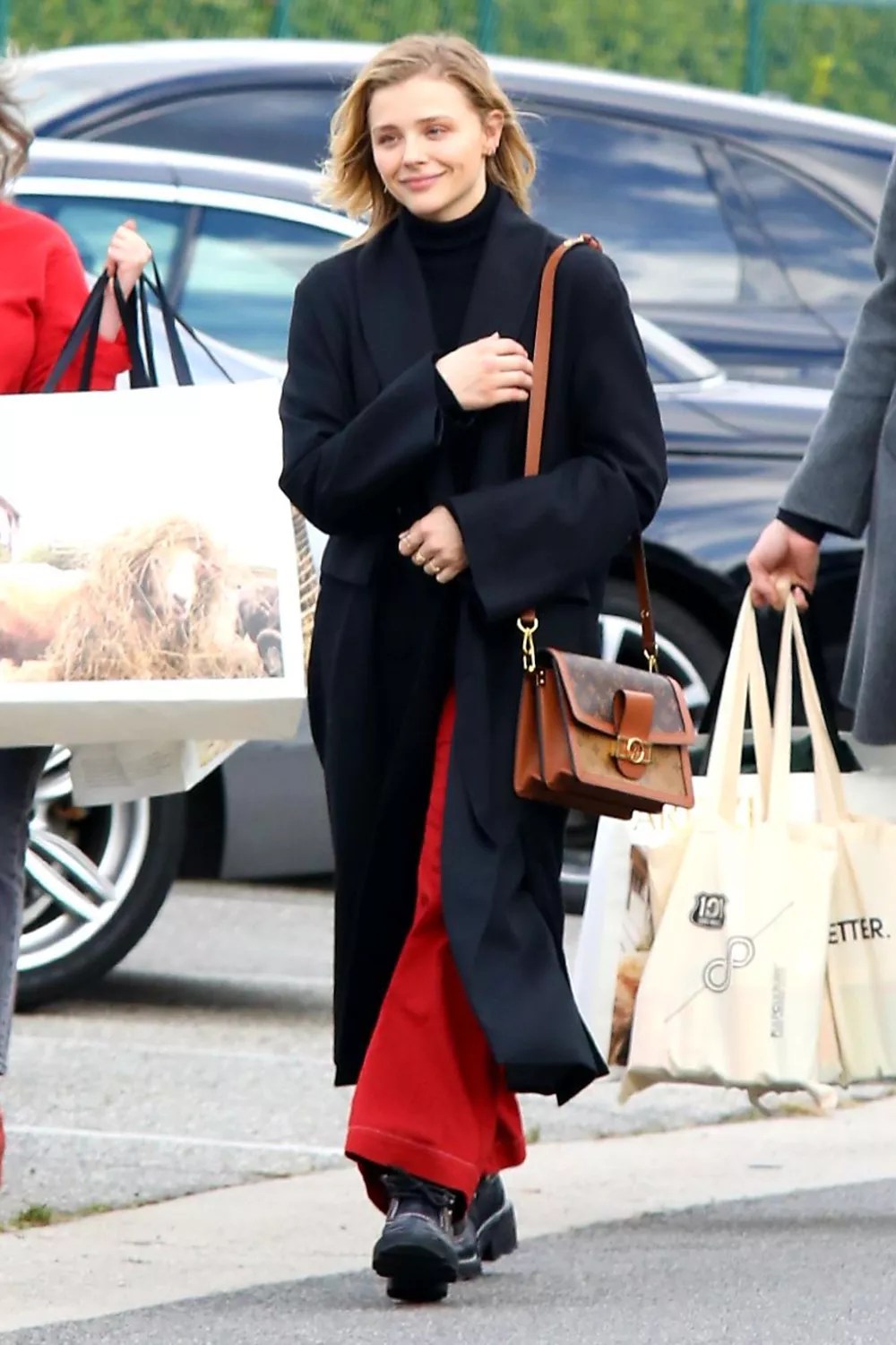 Chloe Moretz seen wearing red pants and black over coat with brother after shopping spree. 16 Jan 2020