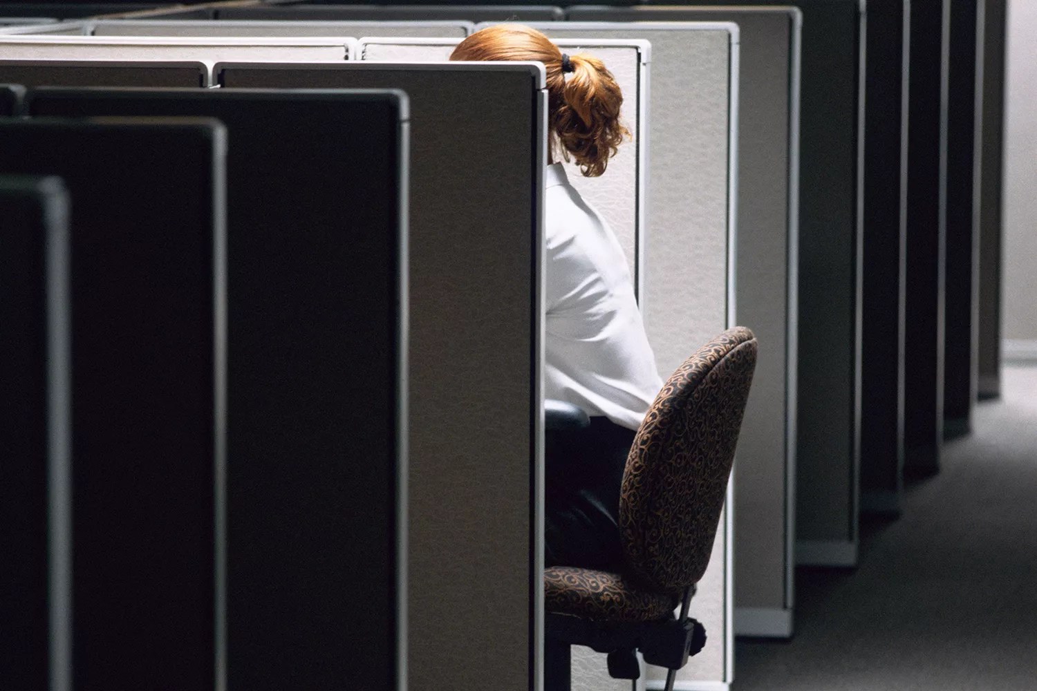 Woman working late in cubicle