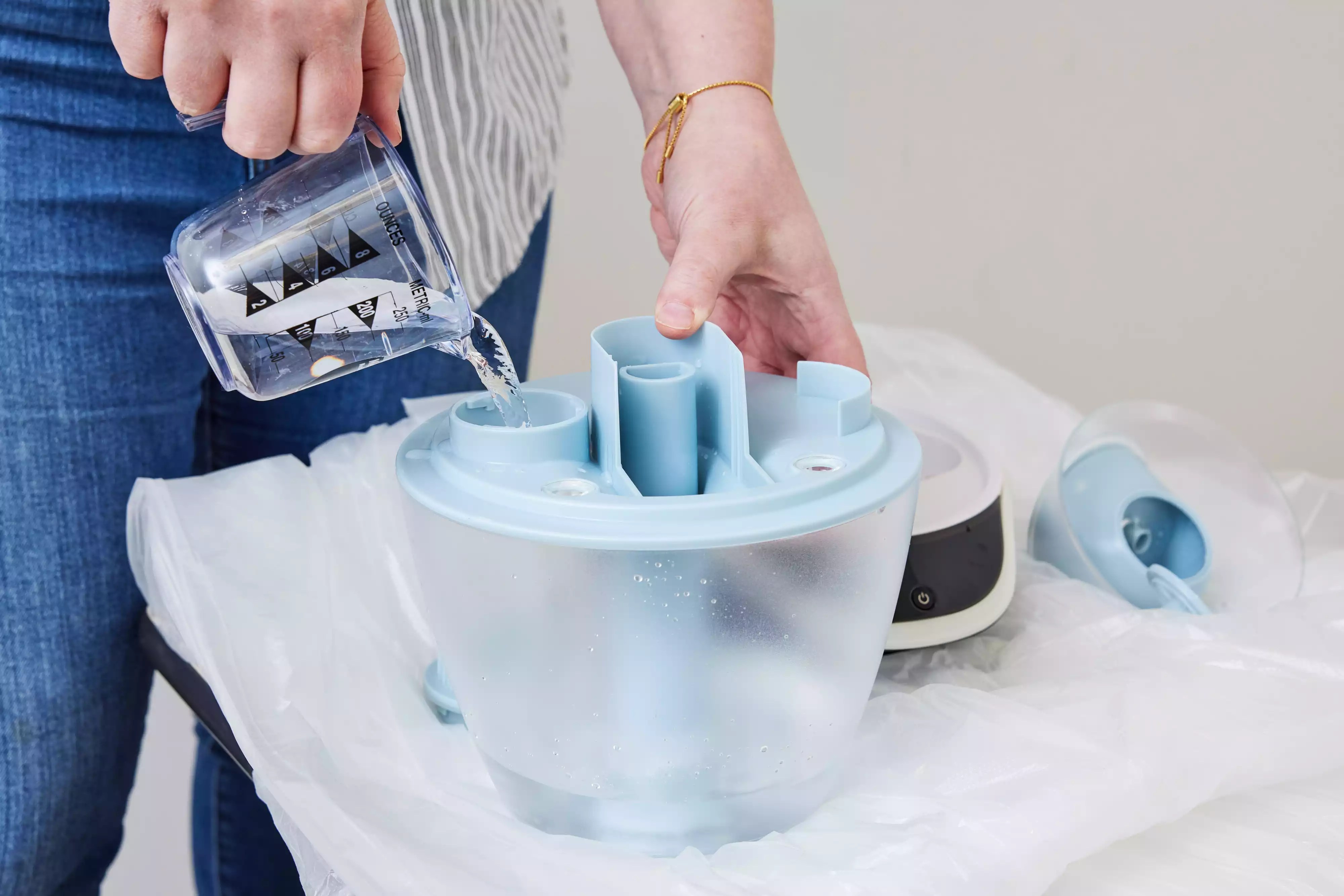 A person pouring water into the Babymoov Hygro Plus Cool Mist Humidifier