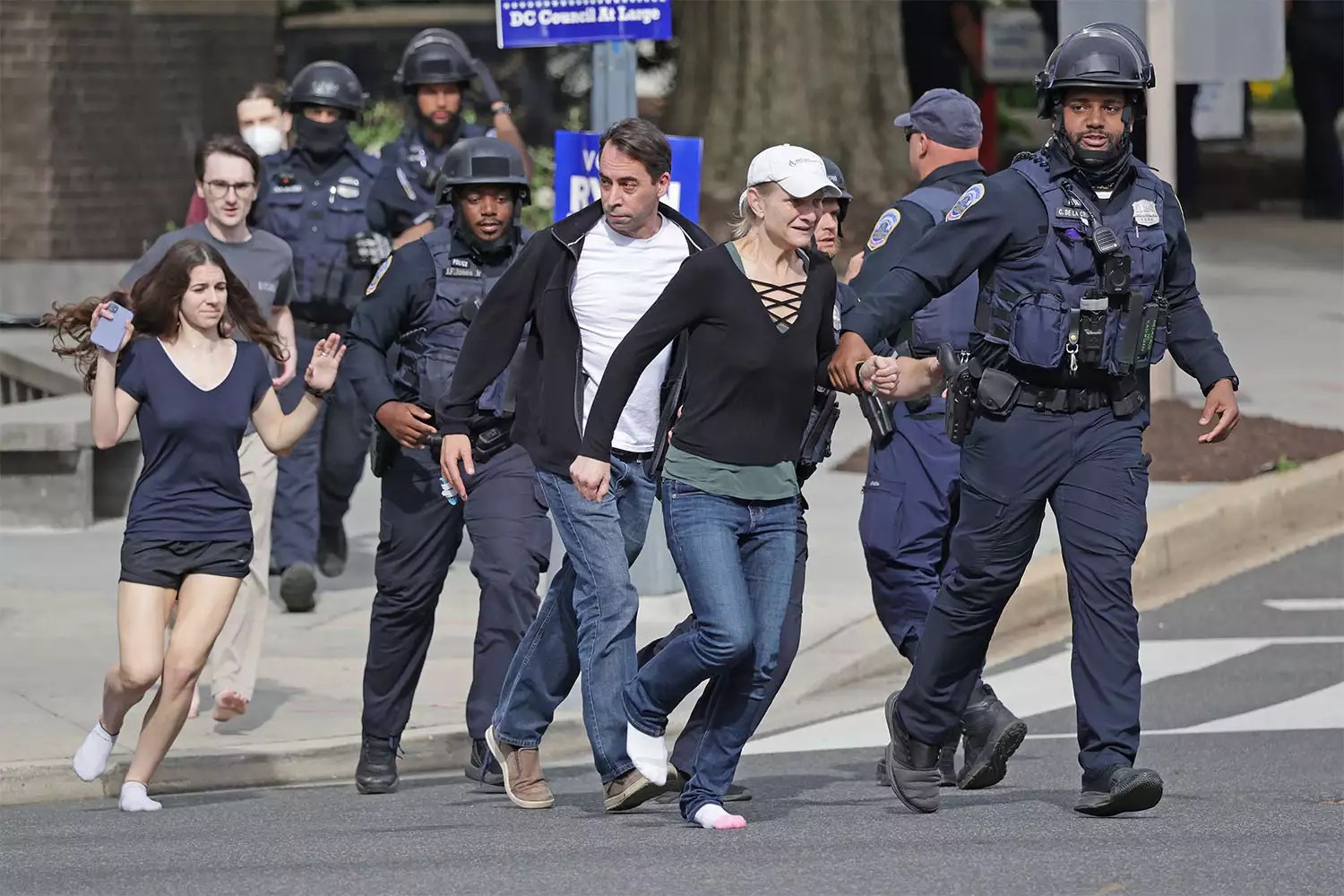 WASHINGTON, DC - APRIL 22: Metropolitan Police run as they escort people, some without shoes, away from a shooting scene in the northwest part of the city on April 22, 2022 in Washington, DC. Police evacuated residents from the shooting scene Friday afternoon and there were reports of several shooting victims. (Photo by Kevin Dietsch/Getty Images)