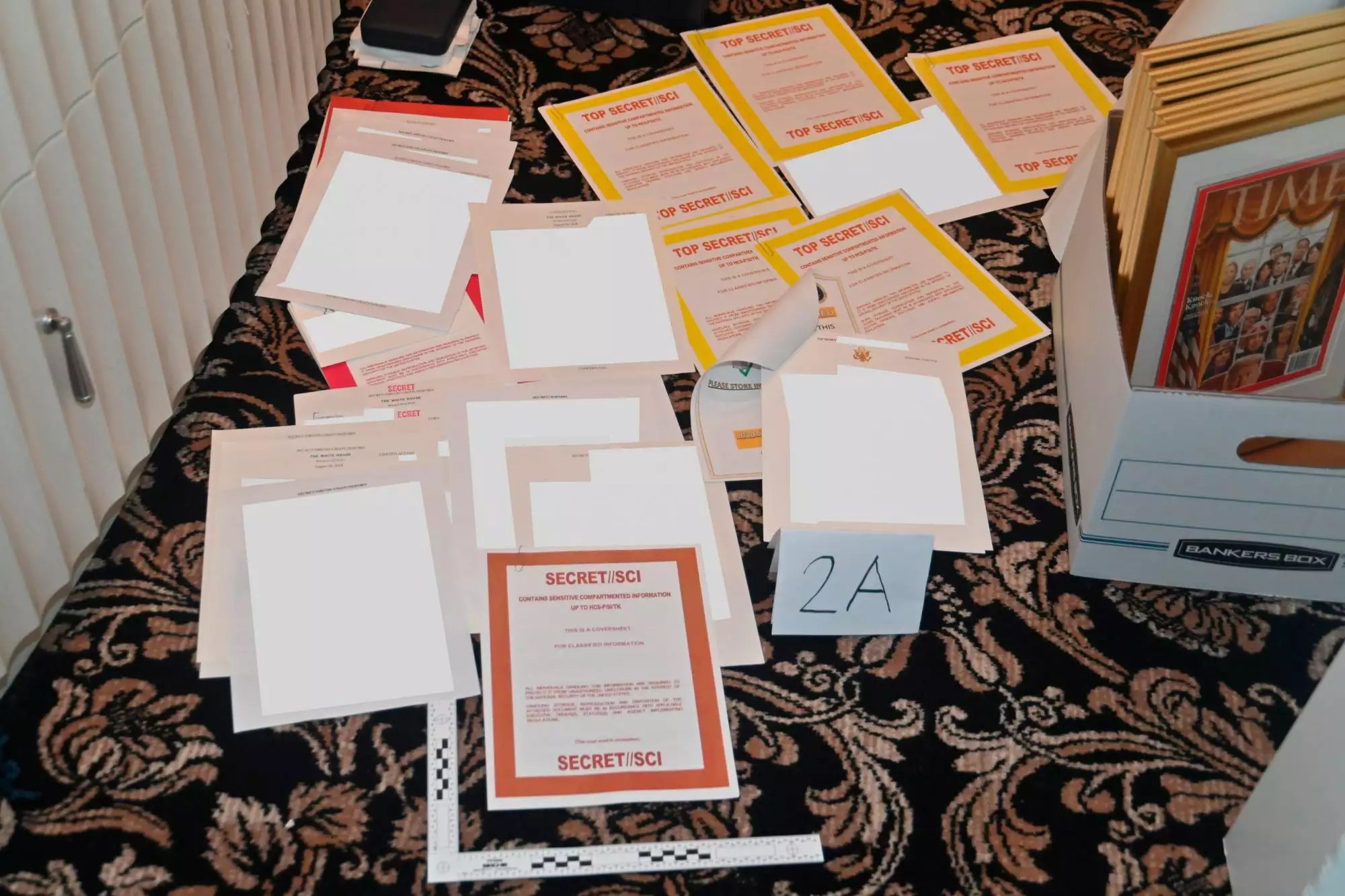 FILE - This image contained in a court filing by the Department of Justice on Aug. 30, 2022, and partially redacted by the source, shows a photo of documents seized during the Aug. 8 FBI search of former President Donald Trump&rsquo;s Mar-a-Lago estate. The FBI search of Donald Trump’s Florida estate has spawned a parallel special master process that this month slowed down a criminal investigation and exposed simmering tensions between Justice Department prosecutors and lawyers for the former president. The probe into the presence of top-secret information at Mar-a-Lago continues. (Department of Justice via AP, File)