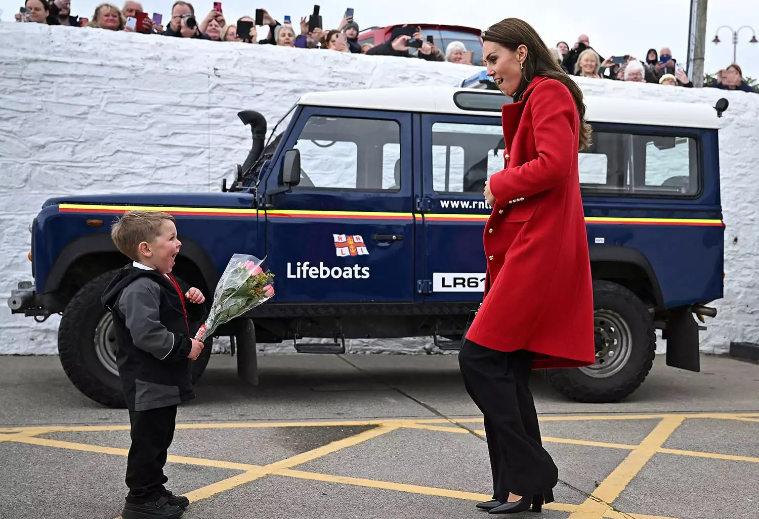 Catherine, Princess of Wales reacts as she is presented with a posy of flowers by four-year-old Theo Crompton during a visit to the RNLI (Royal National Lifeboat Institution) Holyhead Lifeboat Station in Anglesey, north west Wales