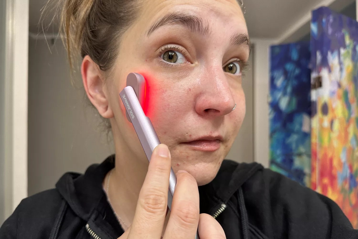 A person uses the SolaWave 4-in-1 Radiant Renewal Skin Care Wand
