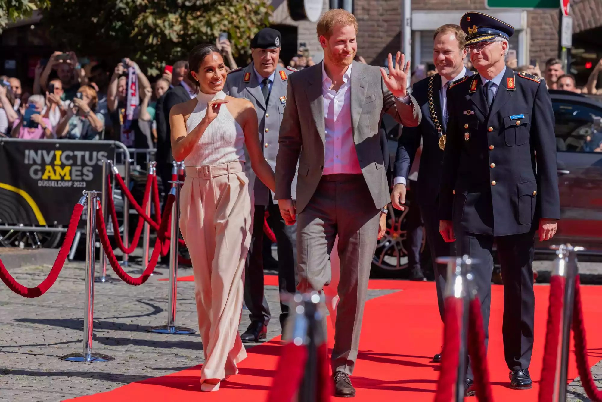 06 September 2022, North Rhine-Westphalia, Duesseldorf: Britain&rsquo;s Prince Harry (3rd from right, Duke of Sussex, and his wife Meghan (l), Duchess of Sussex, arrive in front of City Hall and walk a red carpet alongside Alfred Marstaller (r), Brigadier General, and Stephan Keller (CDU, 2nd from right,), Lord Mayor of the state capital Düsseldorf. The prince and his wife are coming to Düsseldorf to promote the &ldquo;Invictus Games&rdquo; 2023, which Prince Harry helped launch. These are Paralympic competitions for soldiers injured in war. Photo: Rolf Vennenbernd/dpa (Photo by Rolf Vennenbernd/picture alliance via Getty Images)