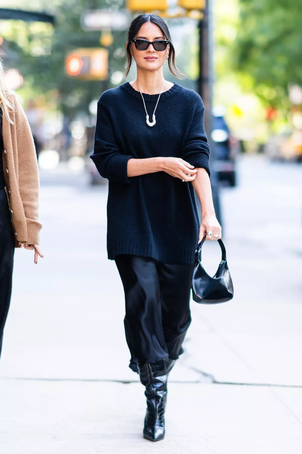 Olivia Munn is all smiles while stepping out in New York City. Munn looked fashionable in a long black sweater, matching skirt, and a pair of black boots.