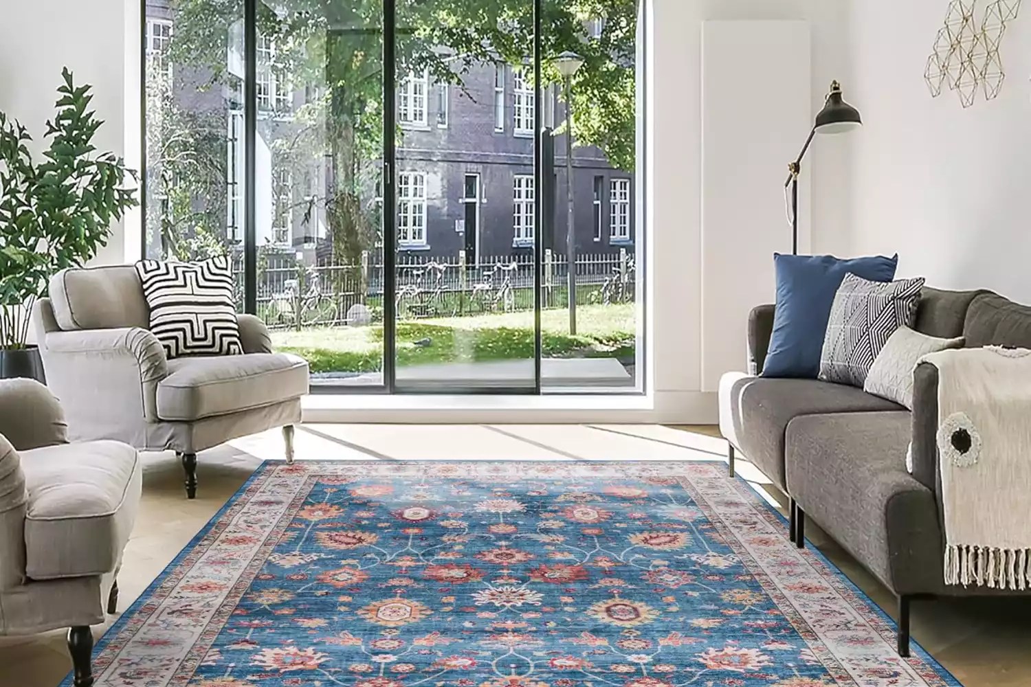 lifestyle image of blue pattern run in living room by patio doors with grey tonal couches
