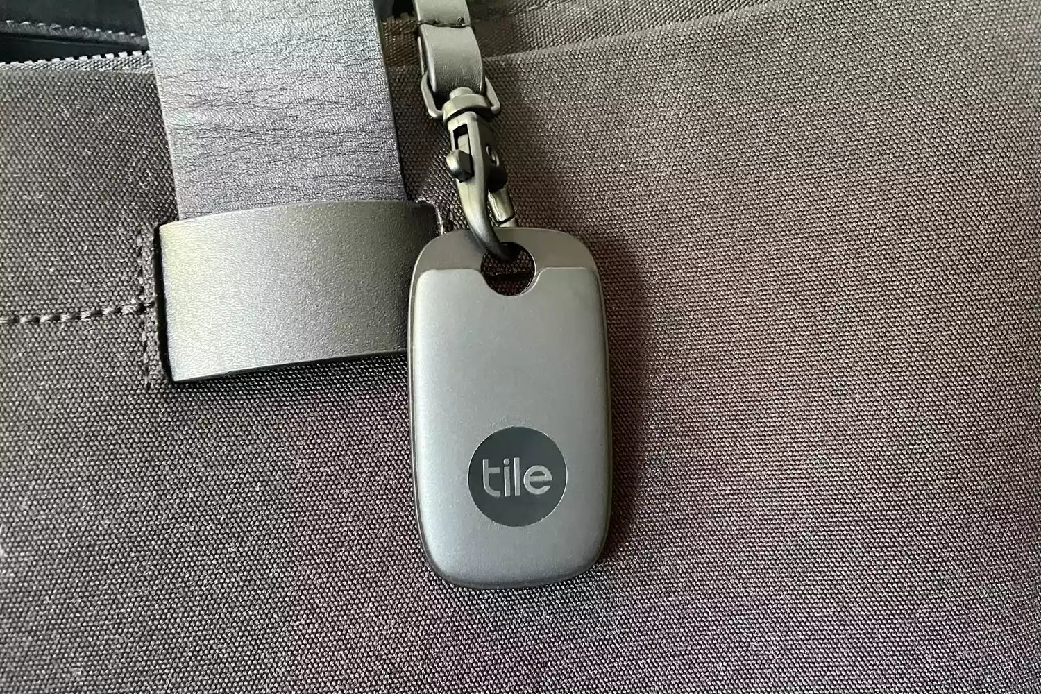 The Tile Pro Bluetooth Tracker clipped to a bag