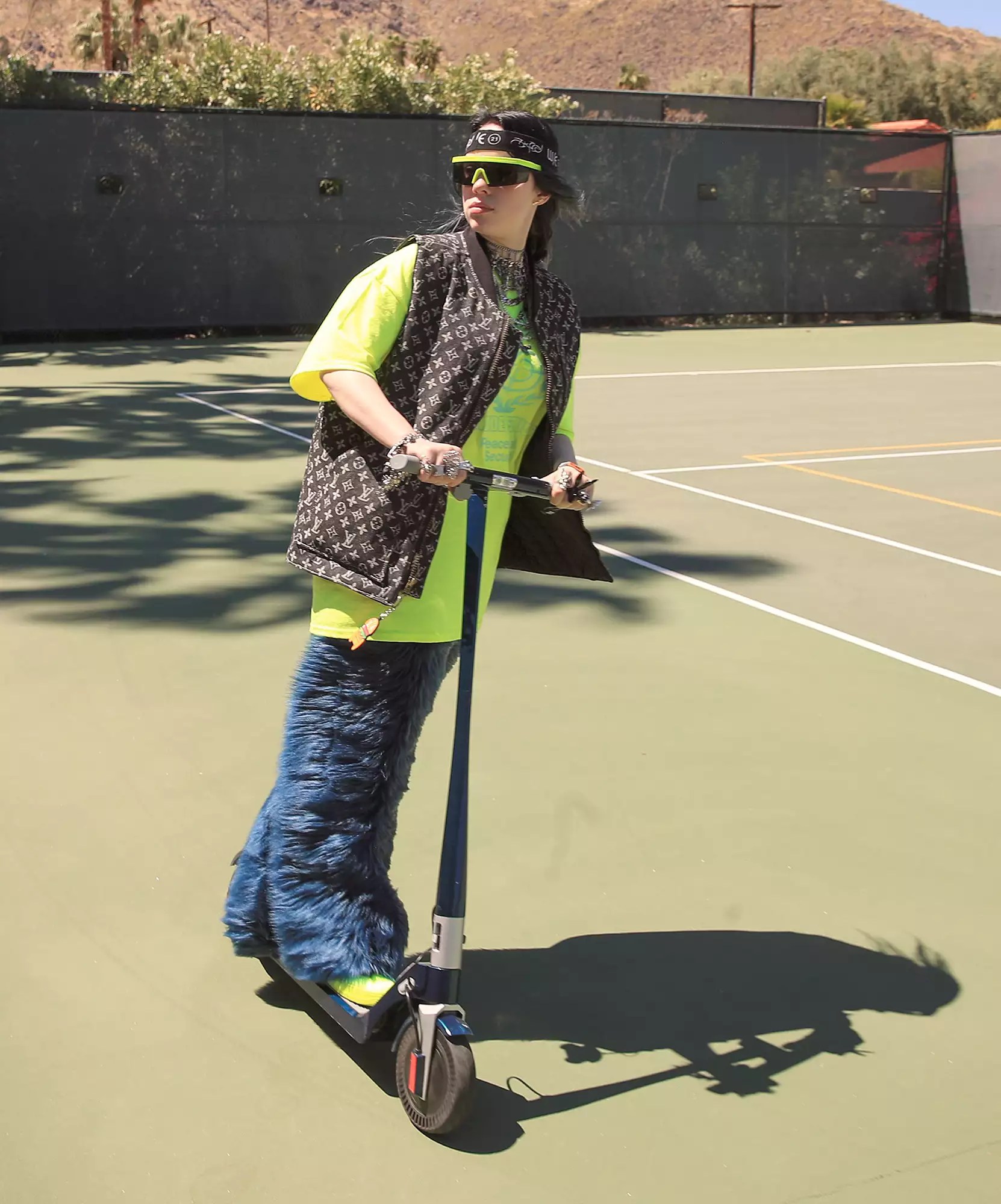 Billie Eilish rides a scooter on the tennis court at the 5th annual Interscope Coachella party.