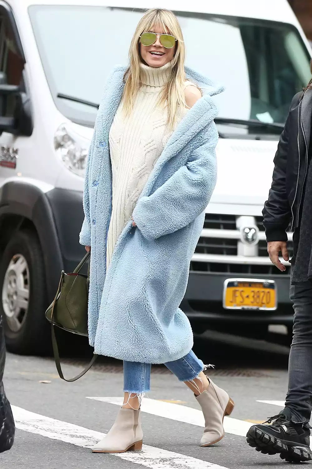 Heidi Klum is seen in a baby blue faux shearling coat, white turtleneck sweater, jeans and suede ankle boots in Soho in New York City