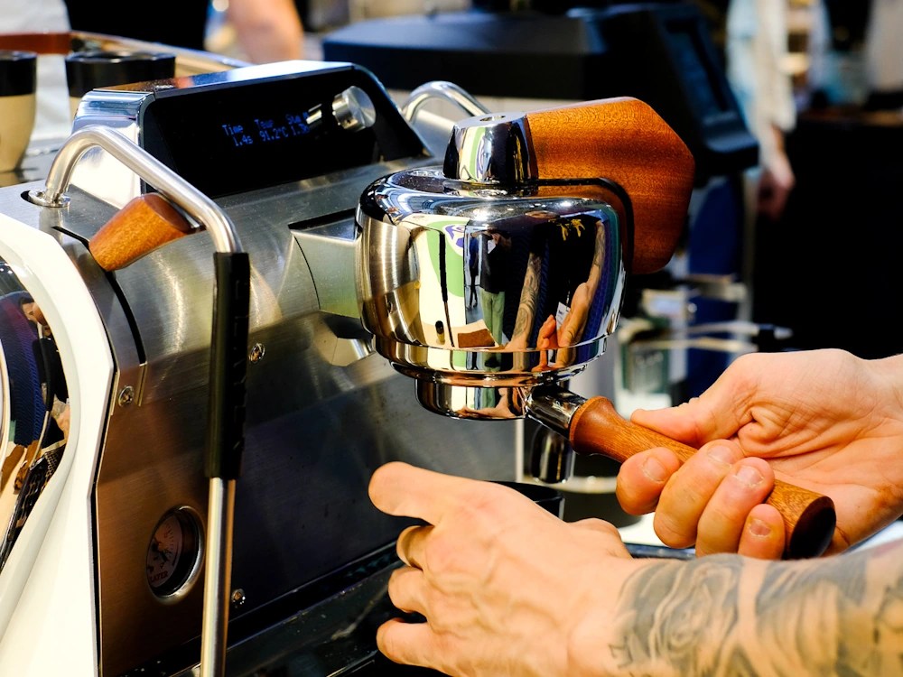- Healthy Brew Hub A barista uses a Slayer espresso machine in a specialty coffee shop.
