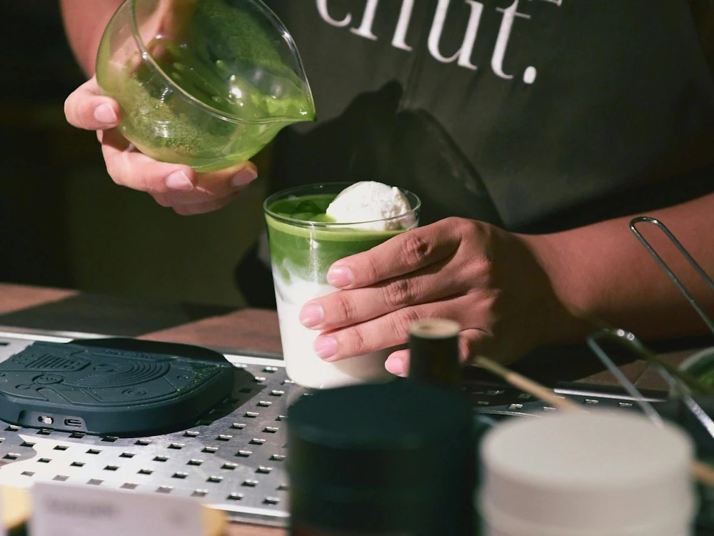healthy brew hub a barista prepares an iced matcha drink
