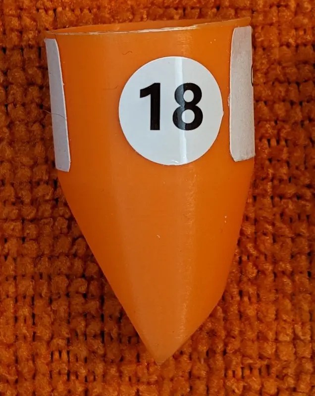 The Original Dimensio Unique Conical 18 size guitar "Pick" against Red Background.