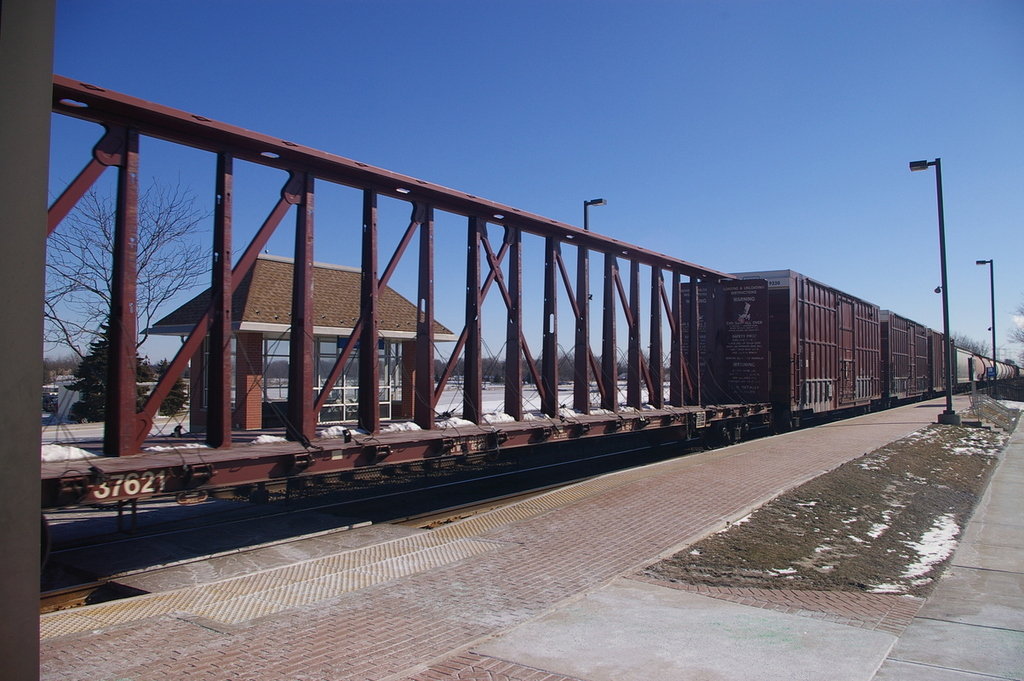 Wheeling, IL a freight train is passing through a Wheeling Metra