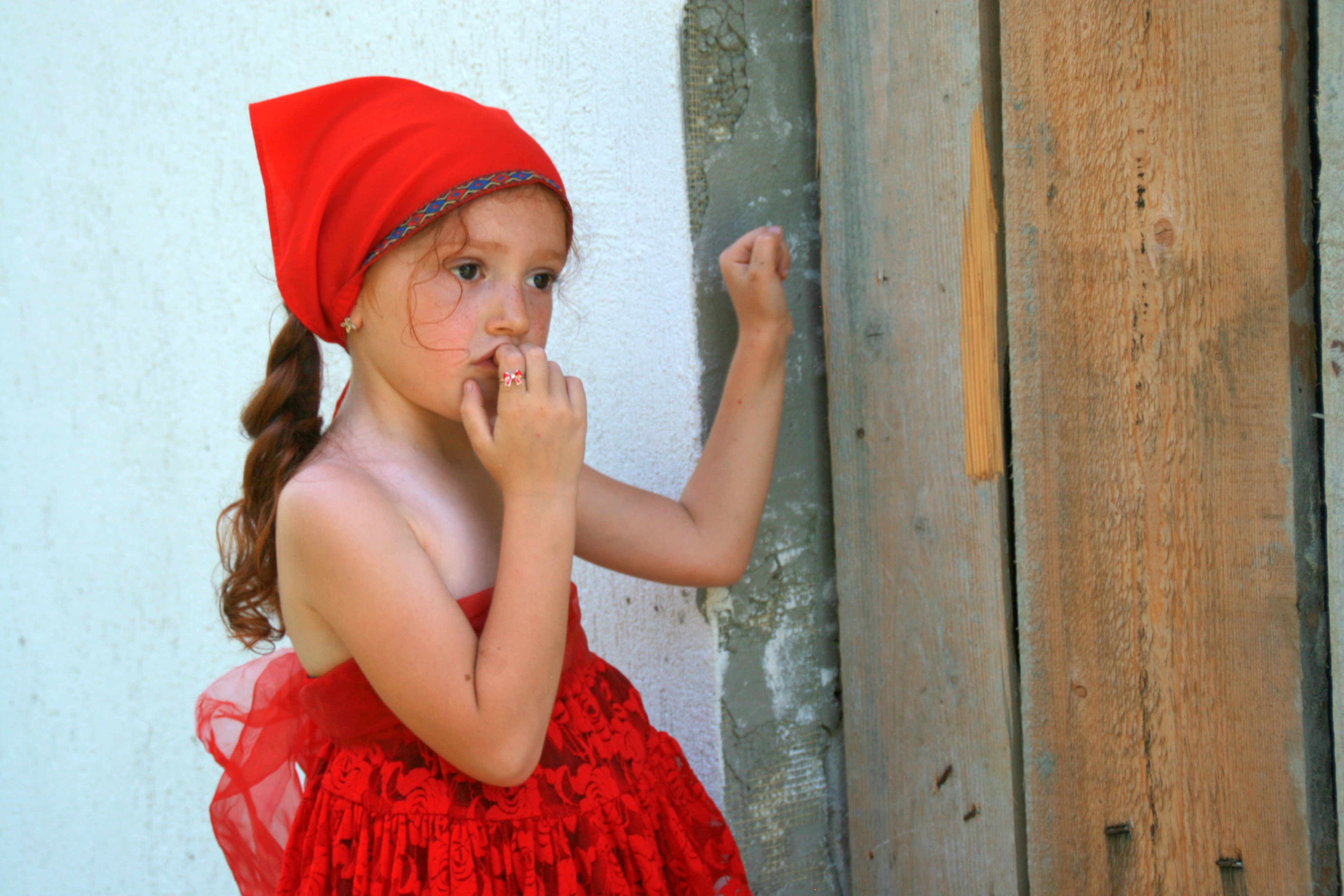 Caucasian child girl in red clothing at wall free image download