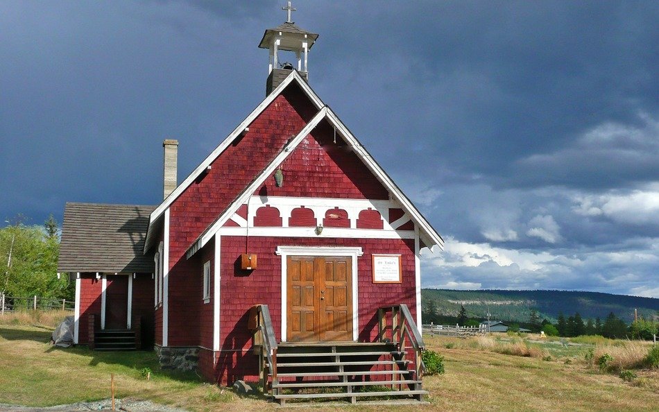Small red church in countryside at thunderstorm sky, canada, british