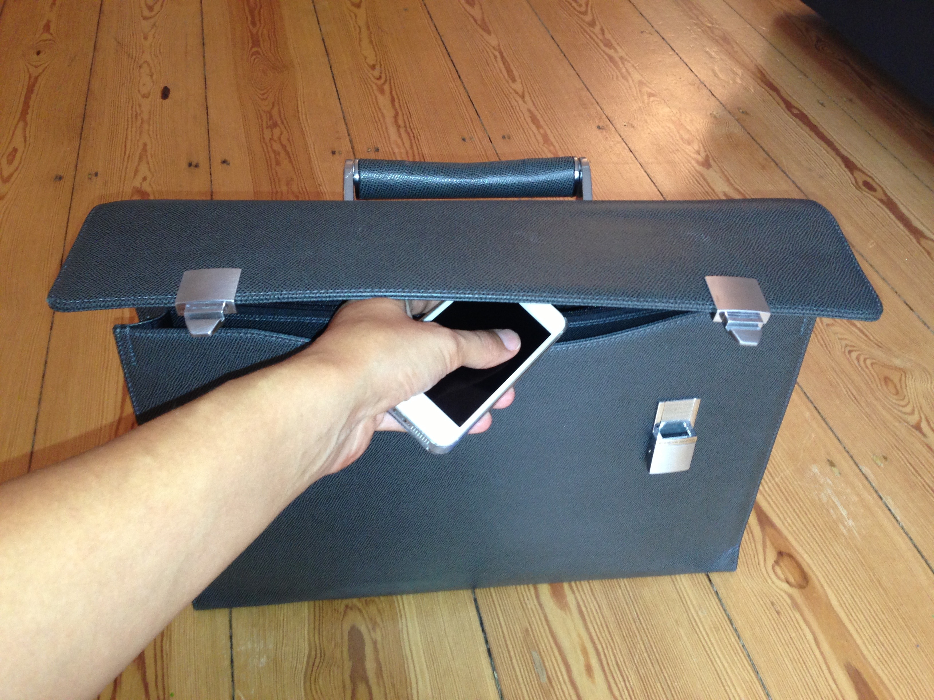 Mobile phone in hand at briefcase free image download