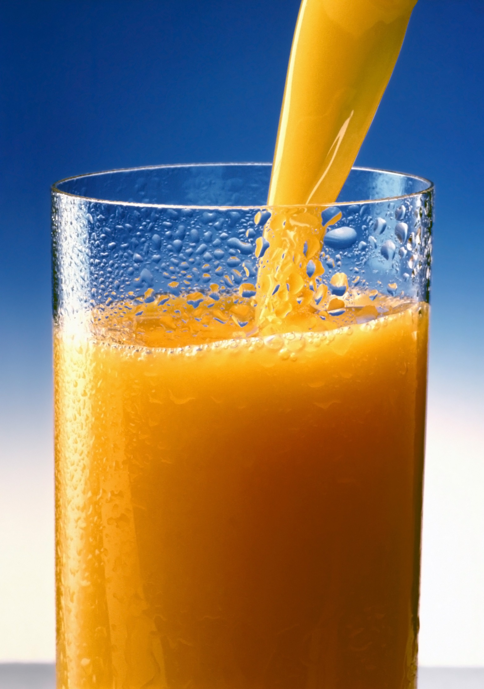 Orange juice is poured into a glass free image download