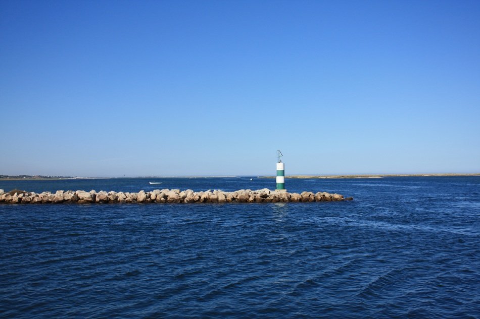 Lighthouse on a rock beach free image download
