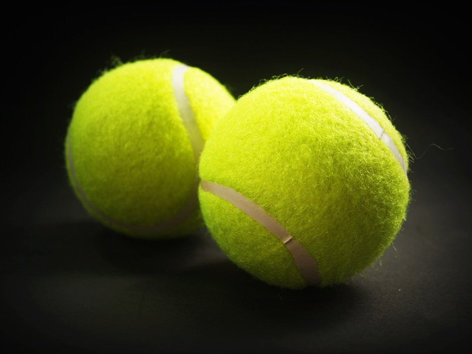 Yellow tennis balls on a dark surface free image download