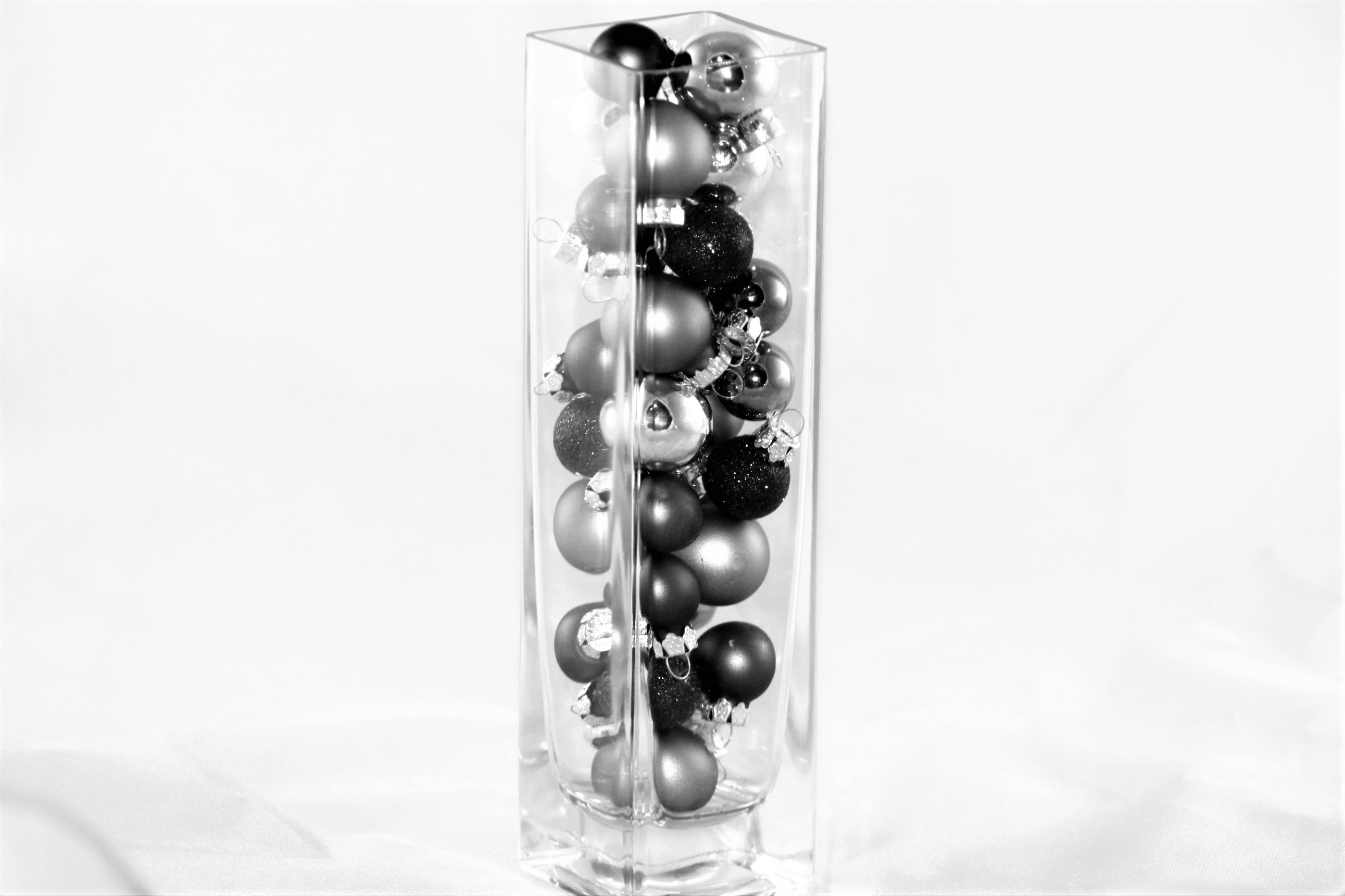 Christmas baubles in glass vase in black and white free image download