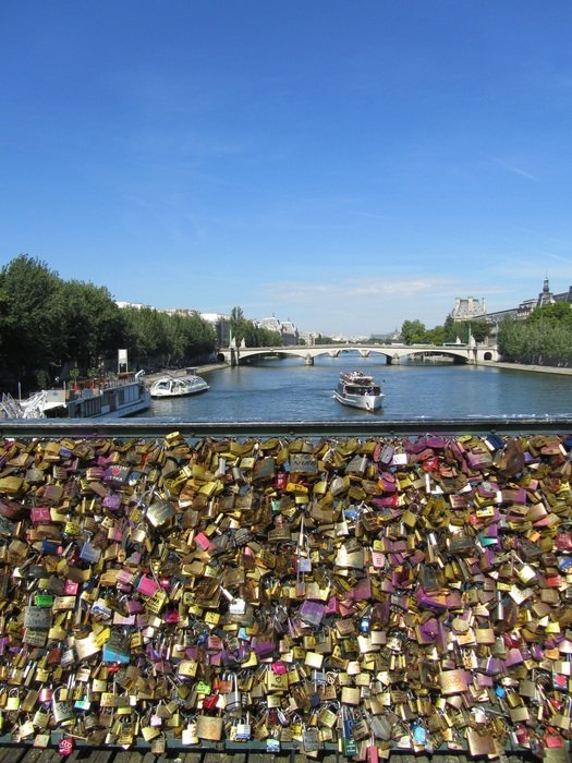Lot of love locks on fence of bridge across Seine river, france, Paris