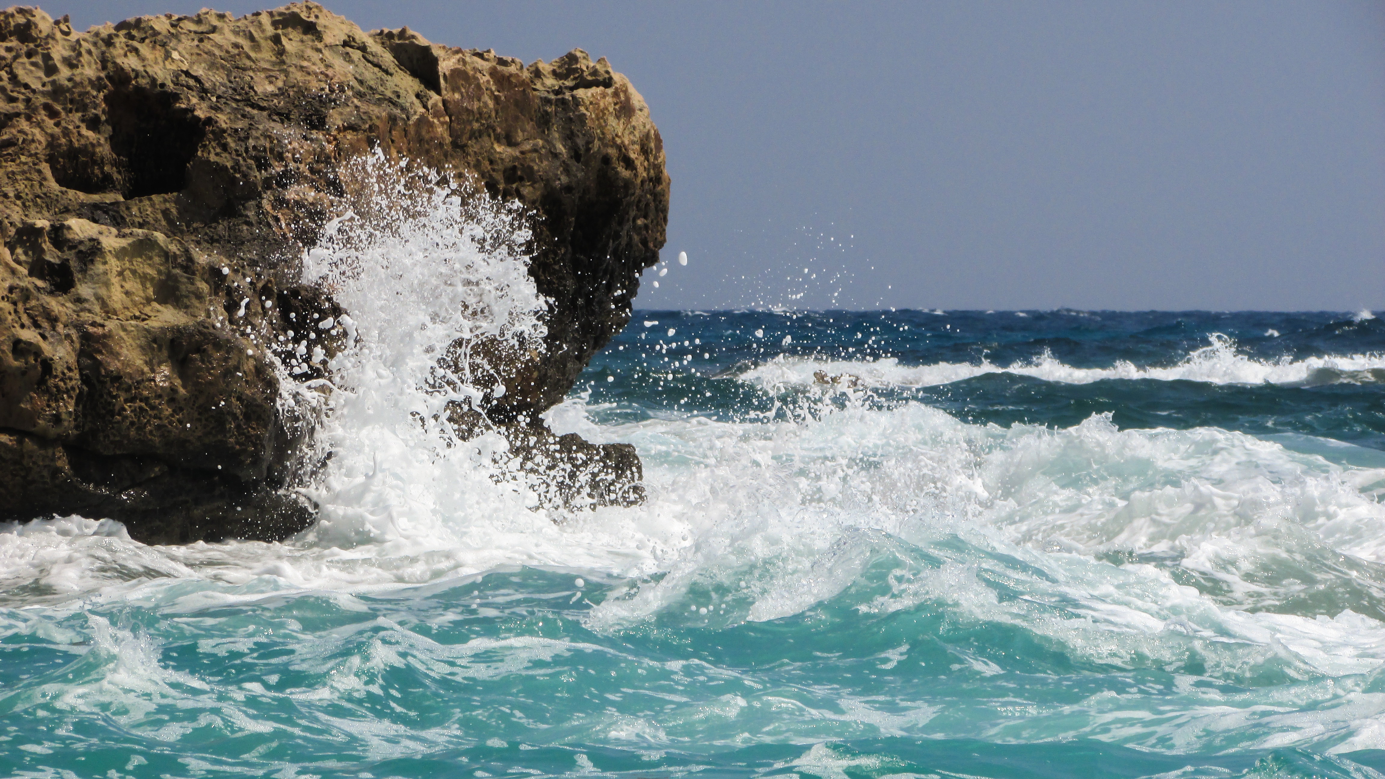 Ocean waves breaking on the rocks free image