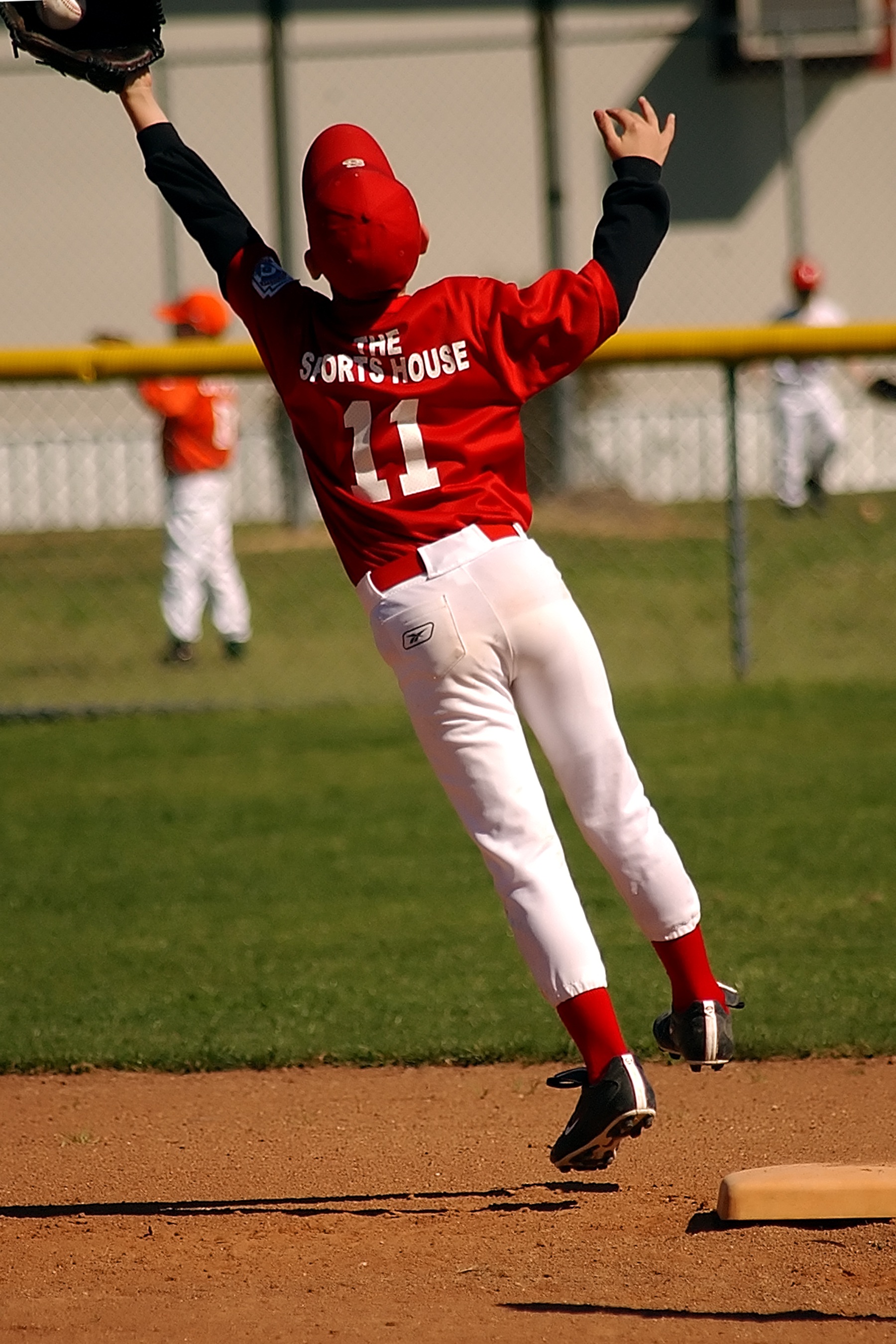 Little baseball player in a jump on competition free image download