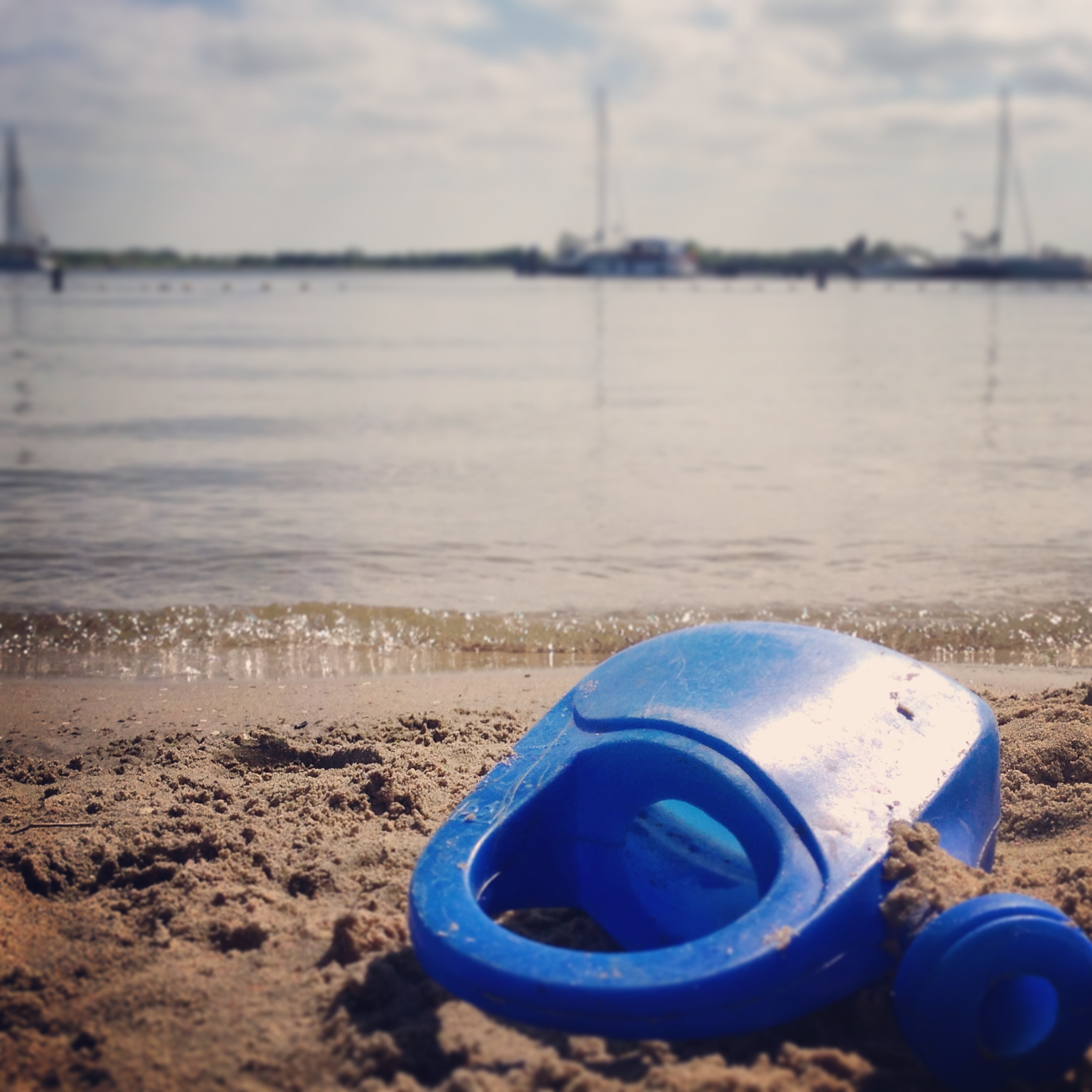 Blue watering can on the beach free image download