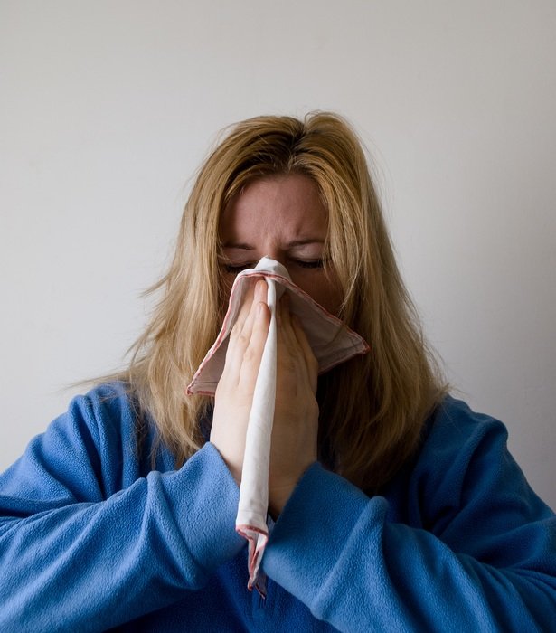 Woman in a blue lab coat blowing his nose free image download