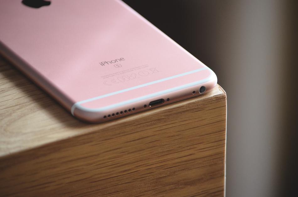 Closeup of the beautiful, pink and white Iphone, laying upside down on