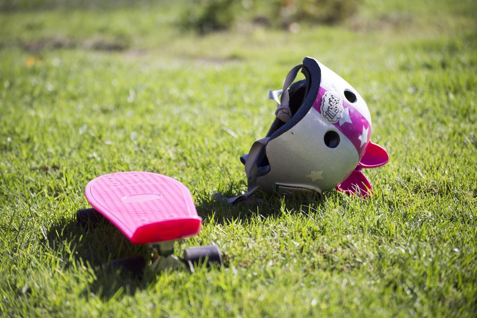 Pink skateboard helmet on green grass free image download