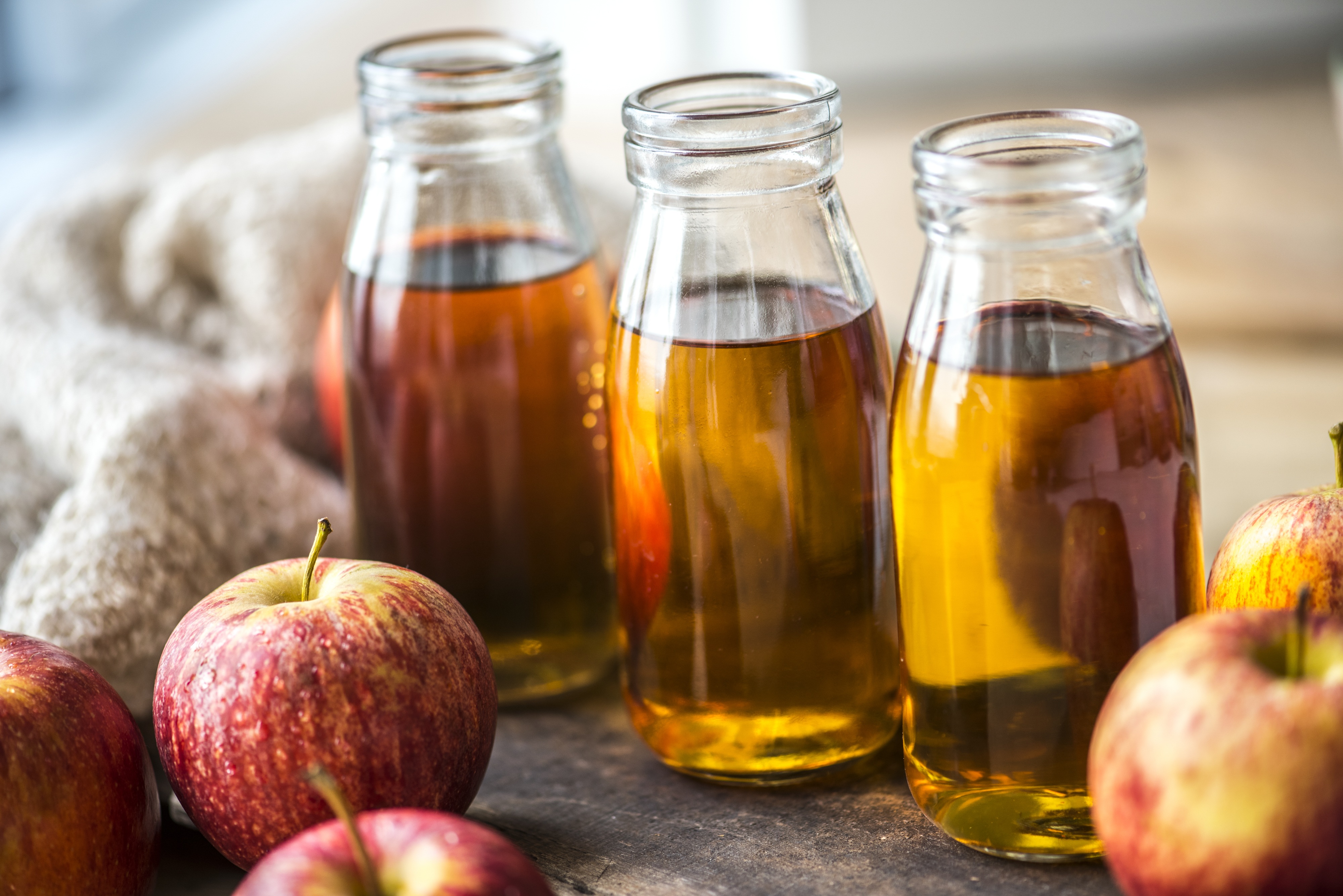 Apple juice in glass bottles on a table with apples free image download