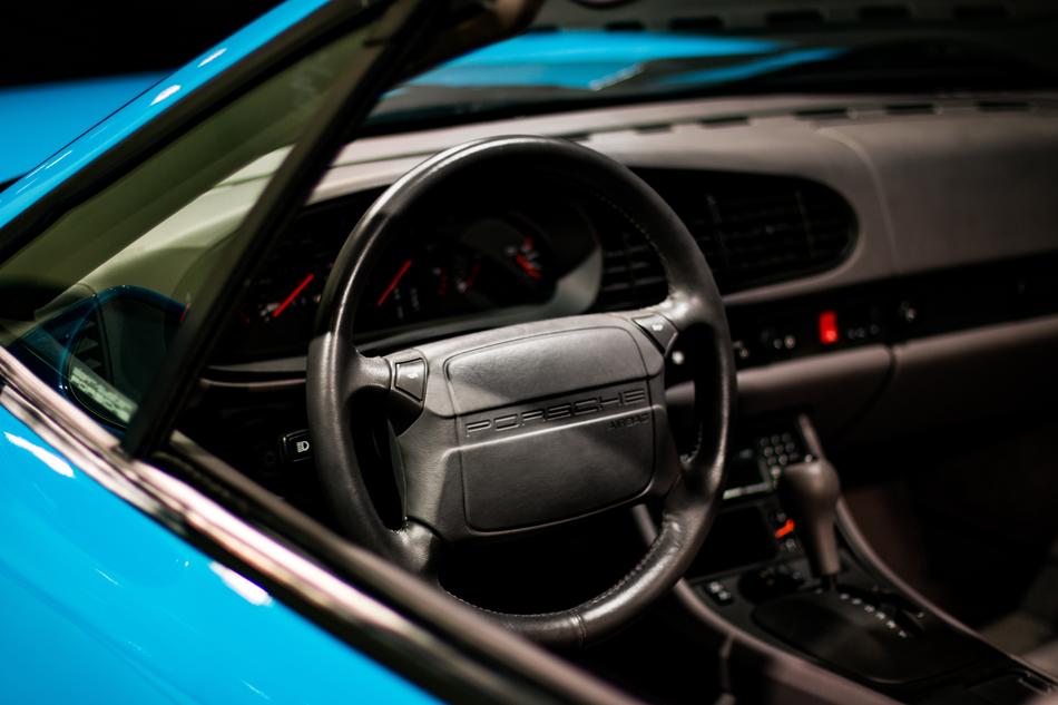 Black interior of the beautiful, shiny, blue Porsche 911 car, with the