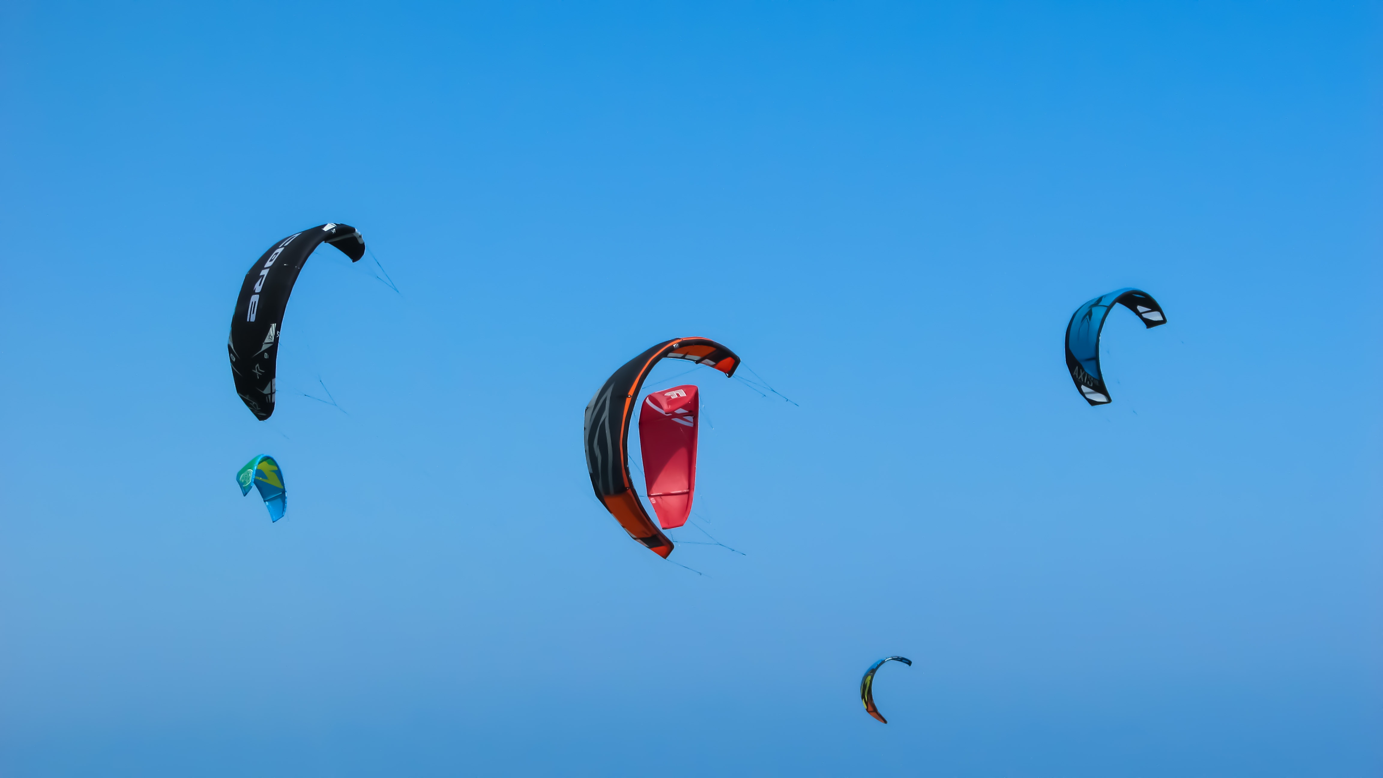 Bright kitesurfing wings at blue sky free image download