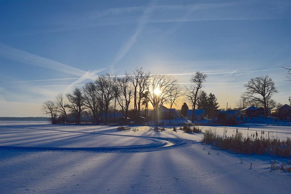 Beautiful landscape of the frozen and snowy Culver Lake among the trees at colorful sunset in