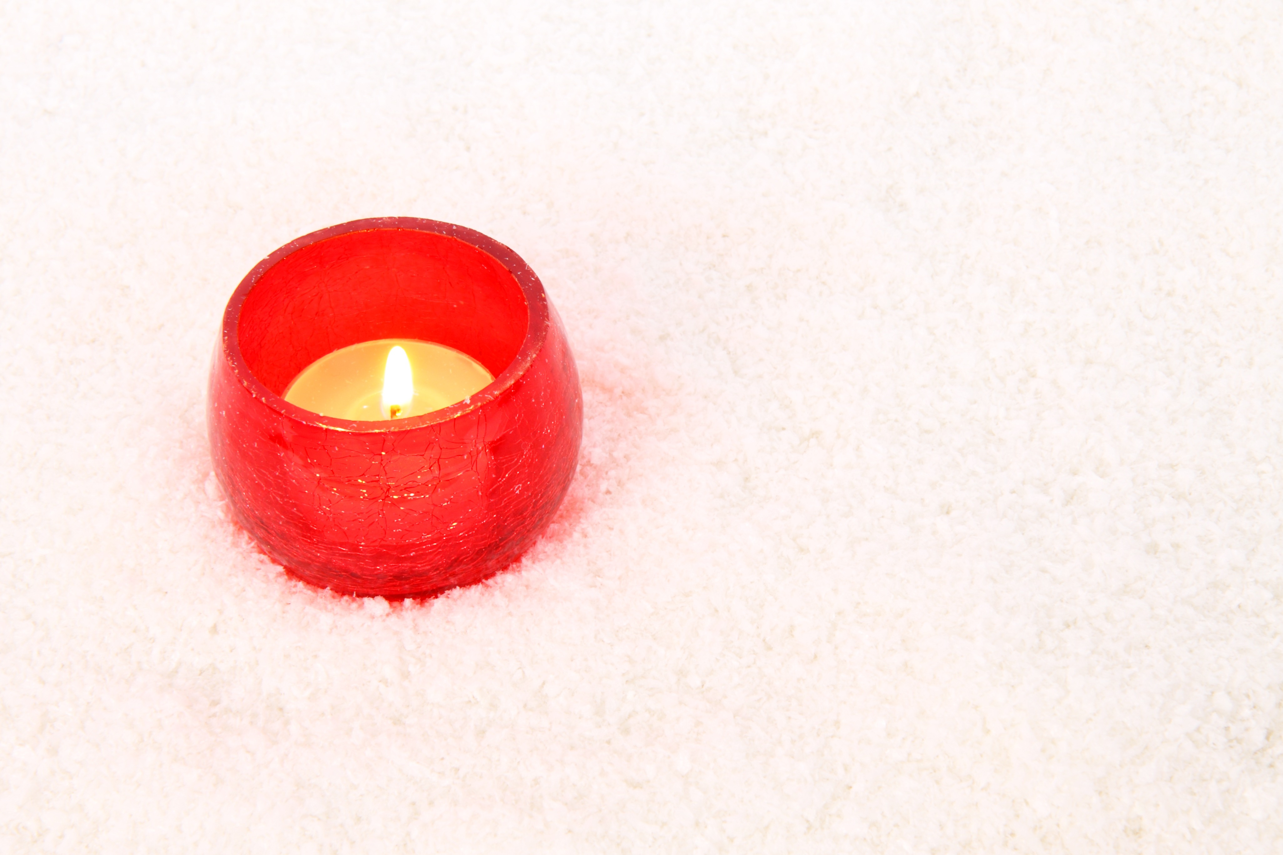 A red candle stands on a blanket free image download