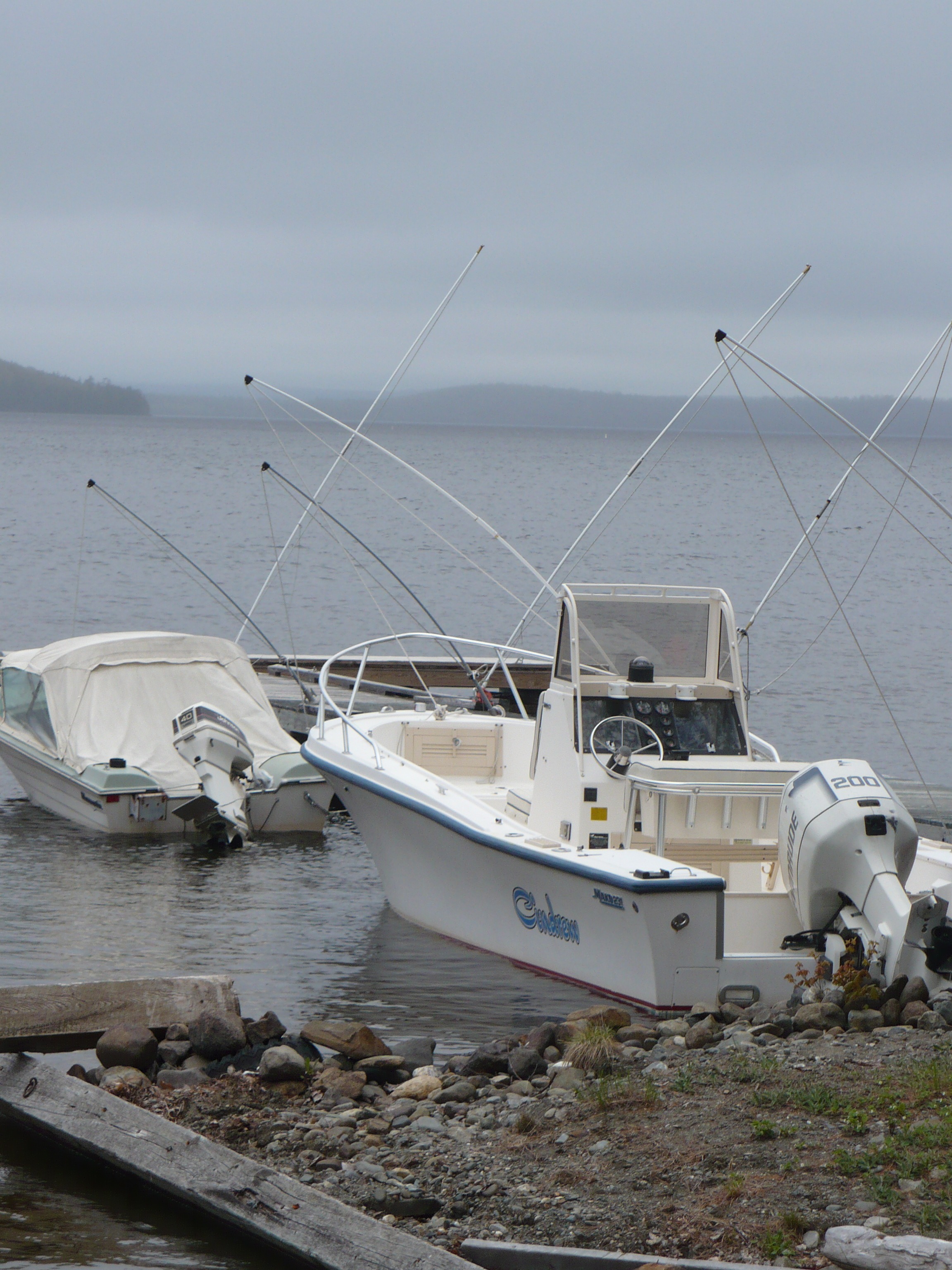 Boats on the coast of Moosehead Lake in USA, under the clouds free