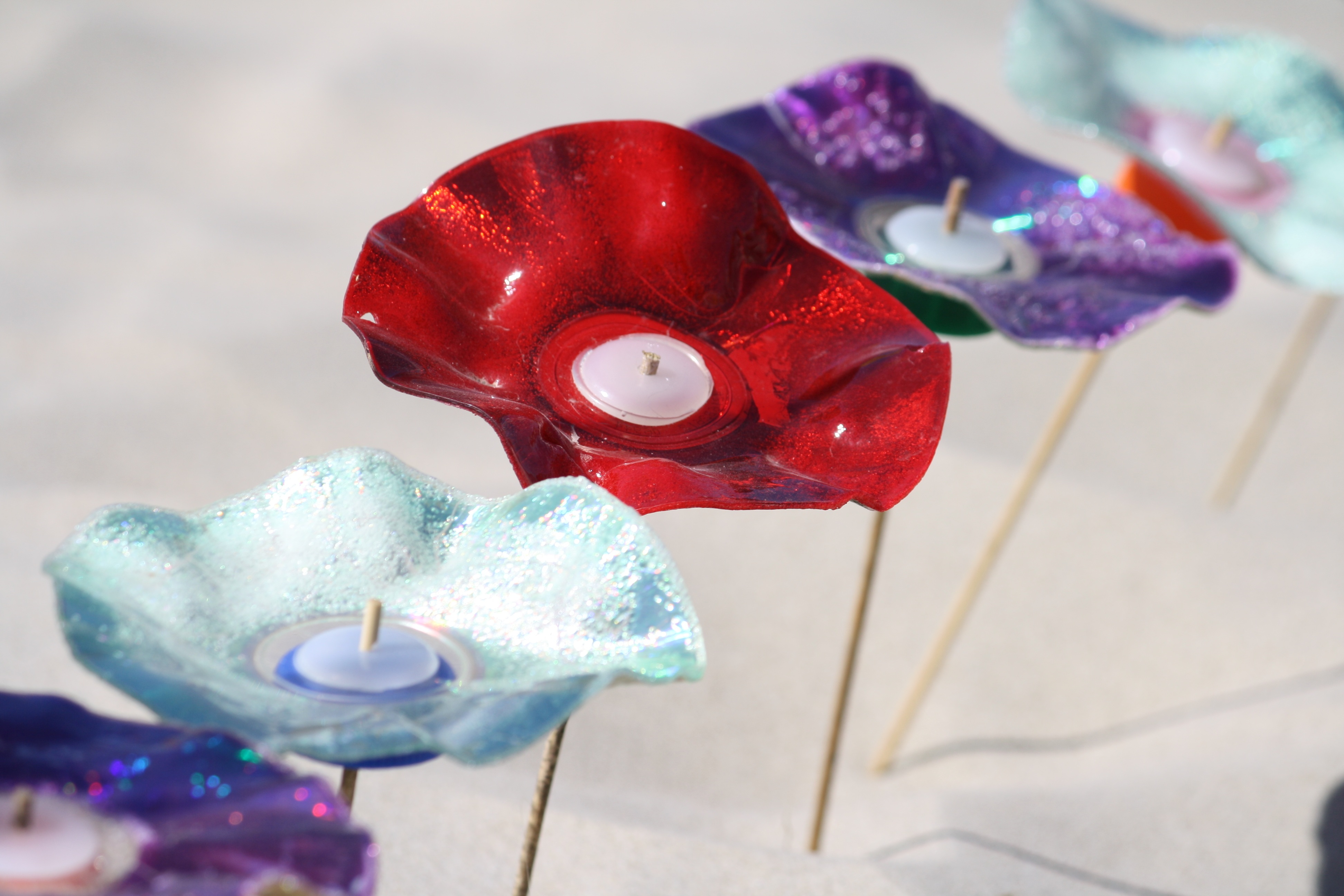 Colorful plastic Flowers on sticks in sand free image download