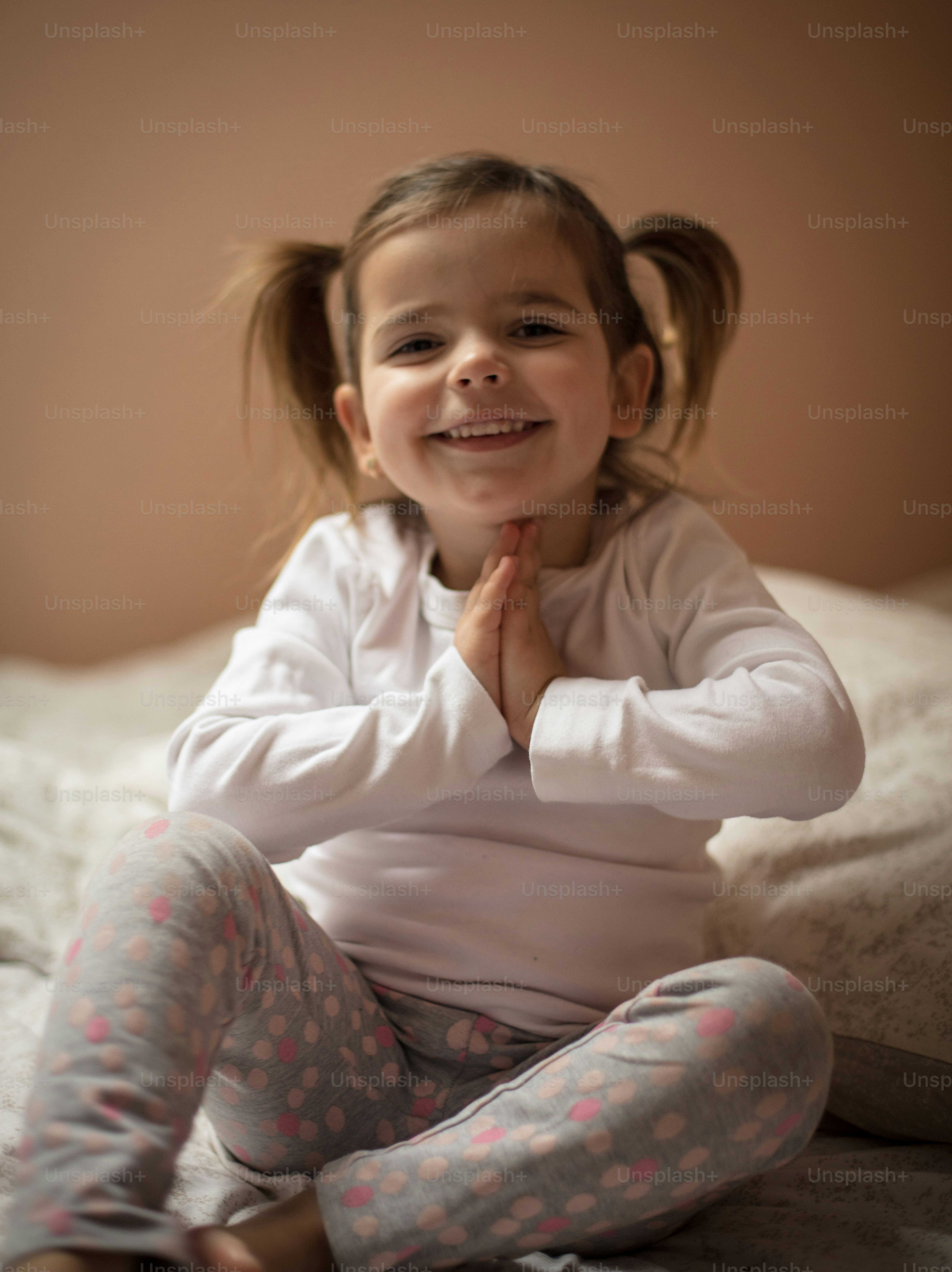 Parents learned to pray before bedtime. Little girl praying on bed. Close up. photo Serbia