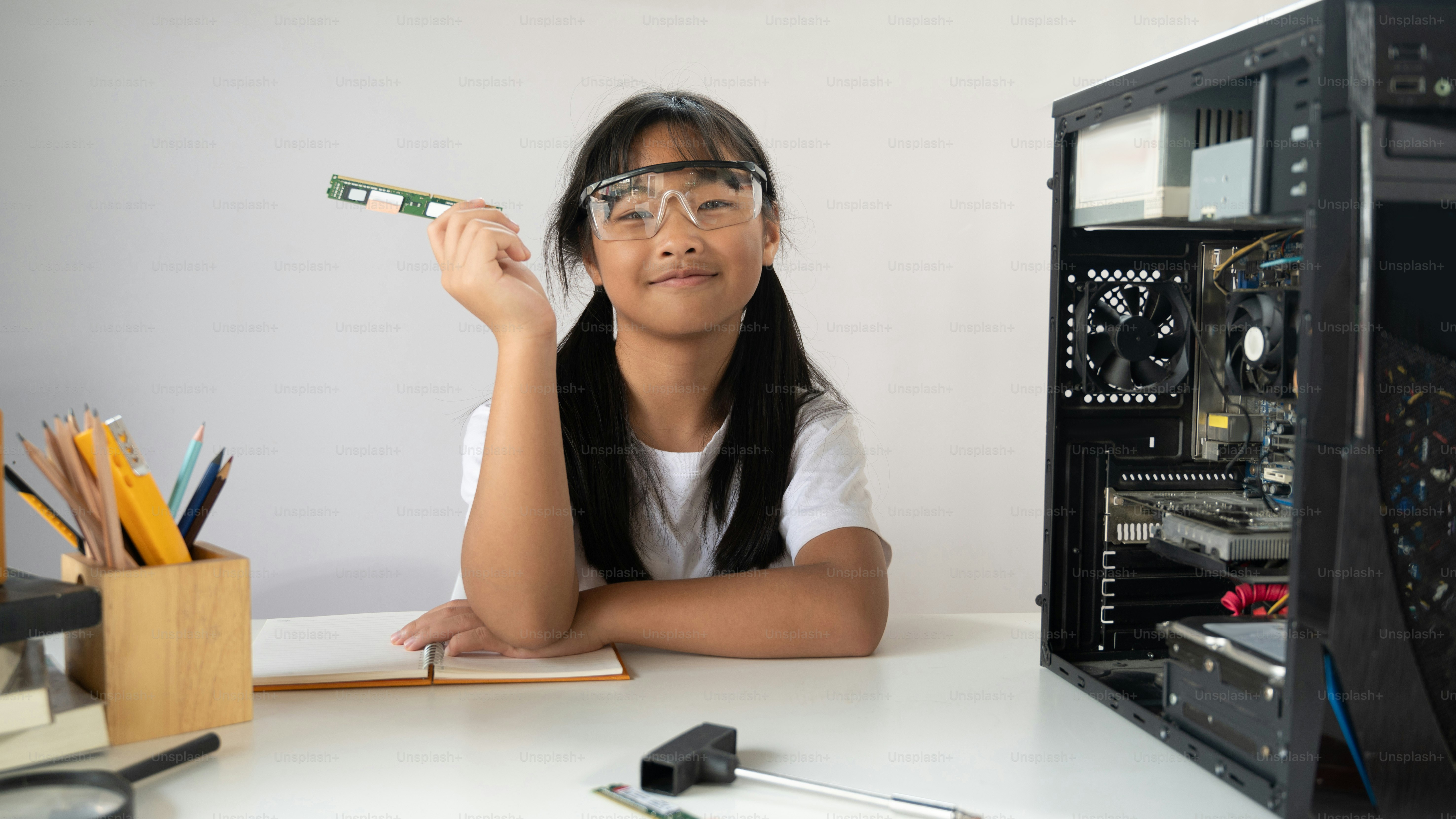 Adorable school girl learning to fix a computer hardware that putting