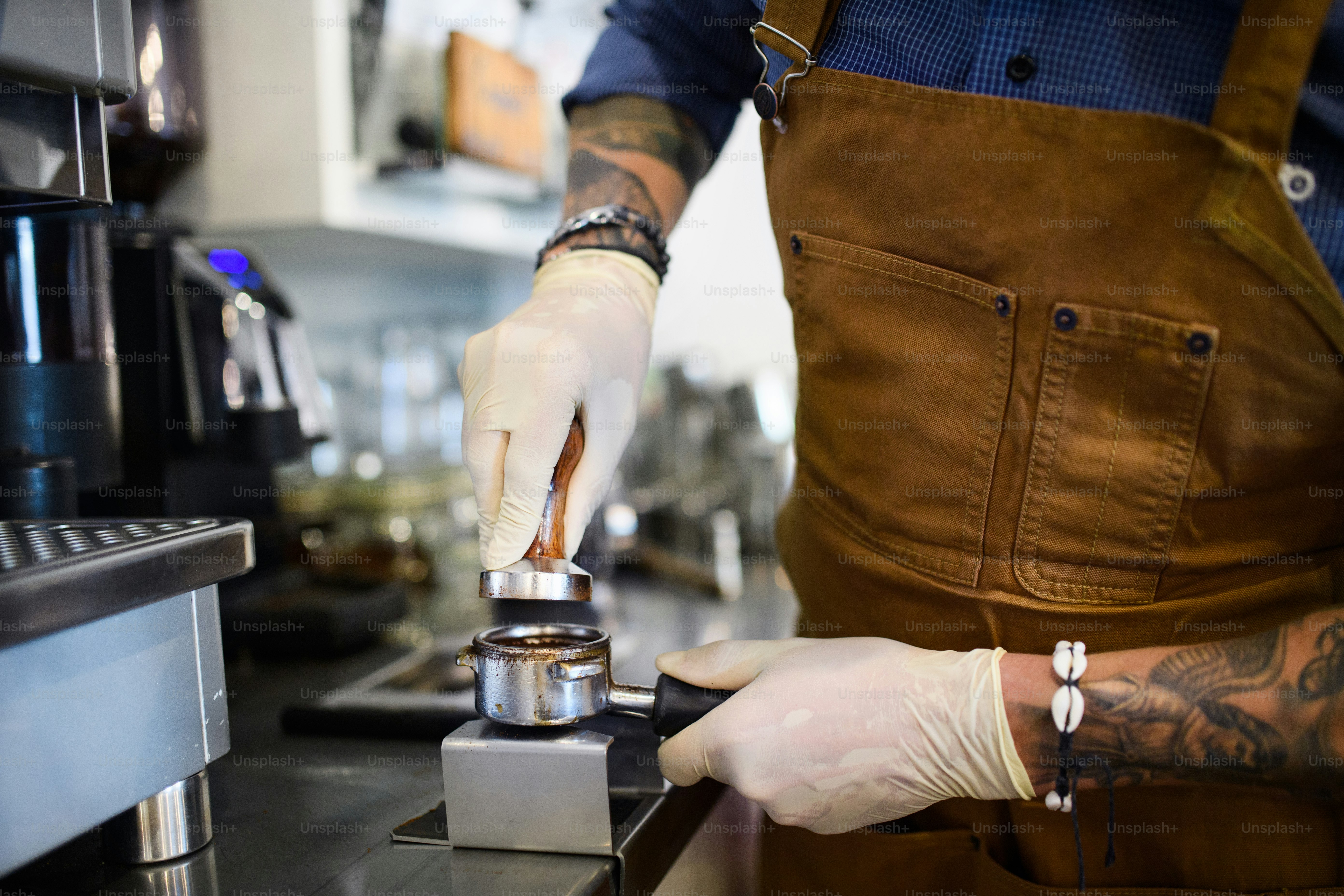 Hipster barista working with gloves, coffee shop open after lockdown