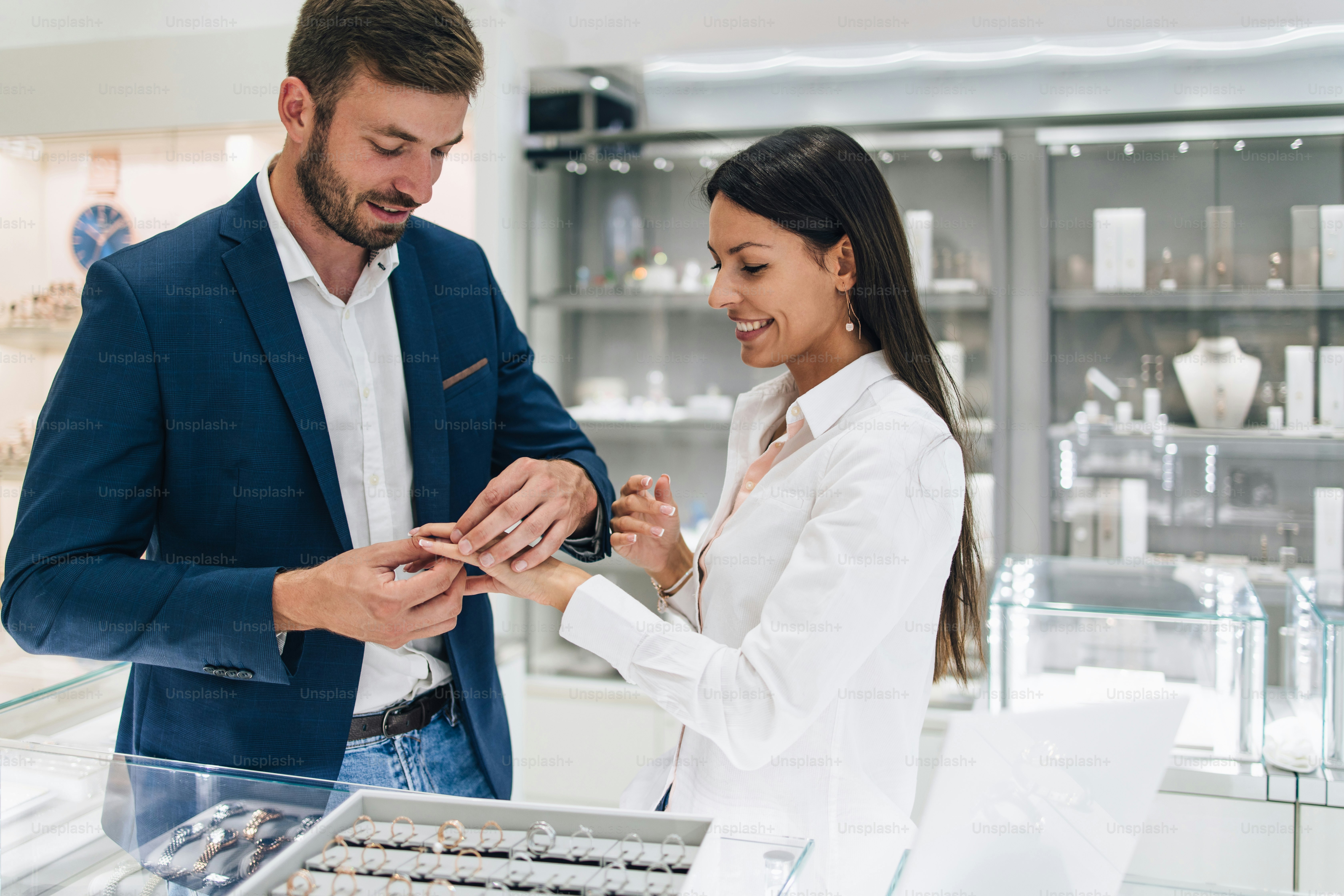 Beautiful couple enjoying in shopping at modern jewelry store. Close up