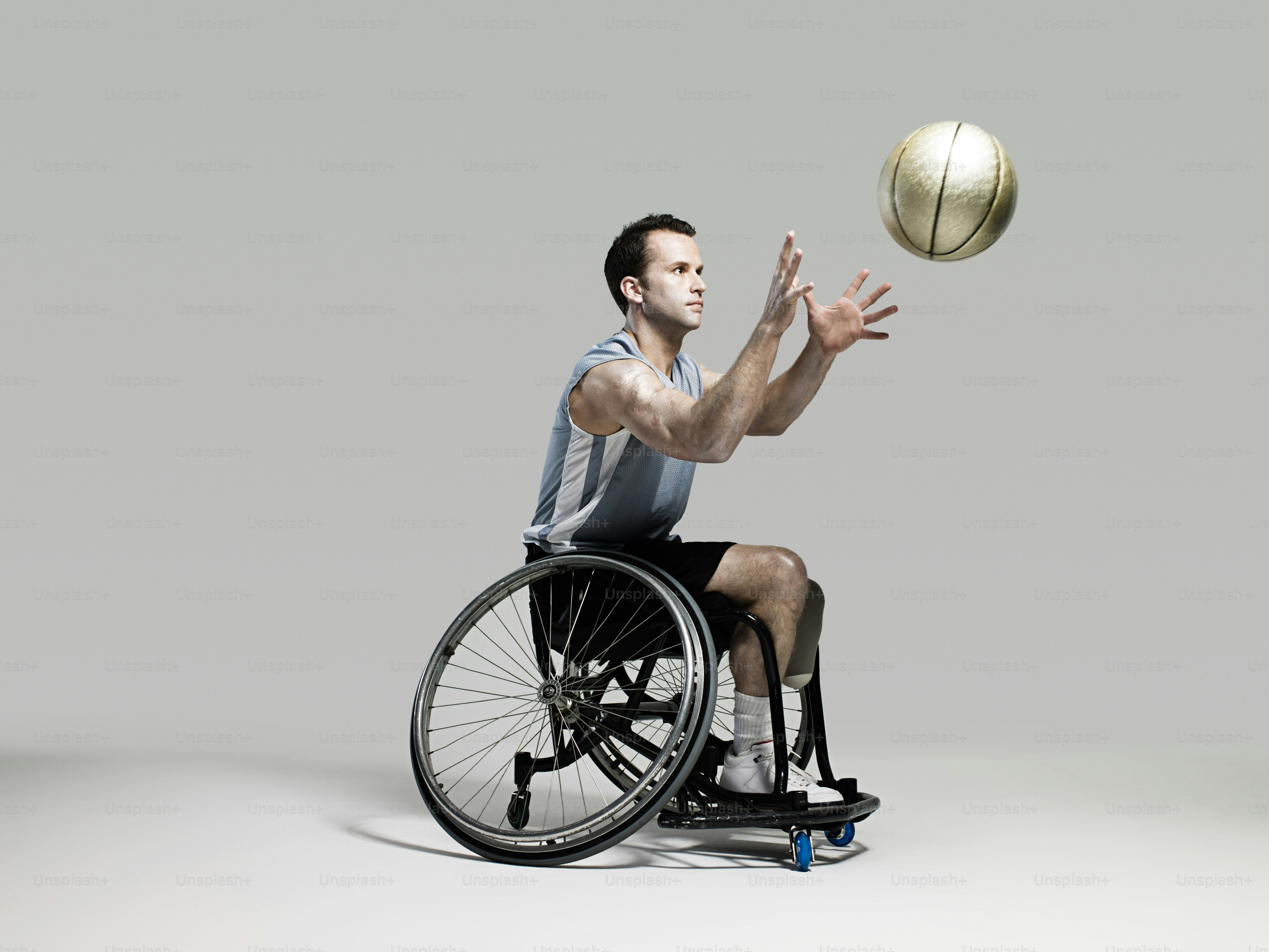 A man in a wheelchair throws a basketball photo Persons with