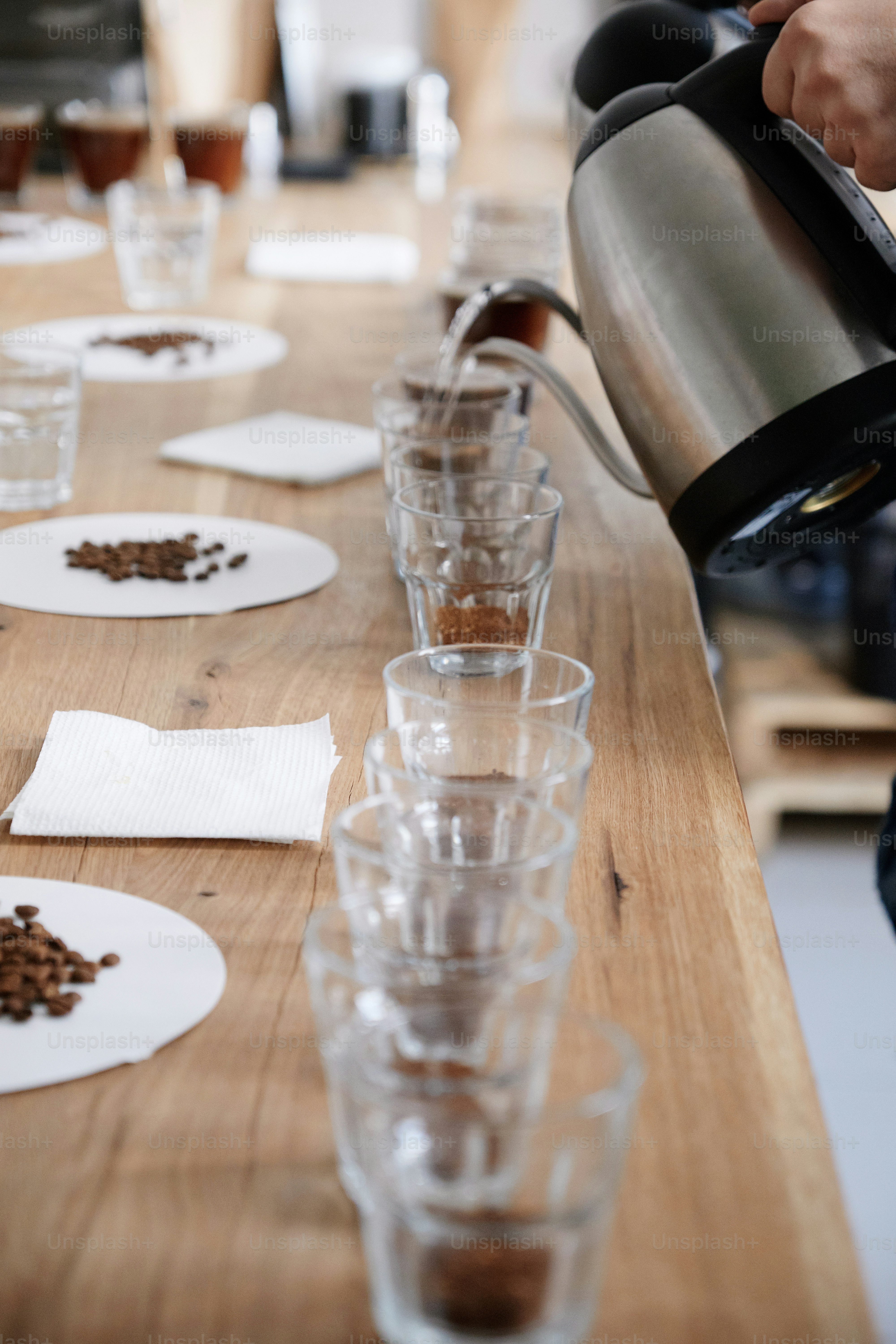 Close up of male barista pouting boiling water into glass cups with