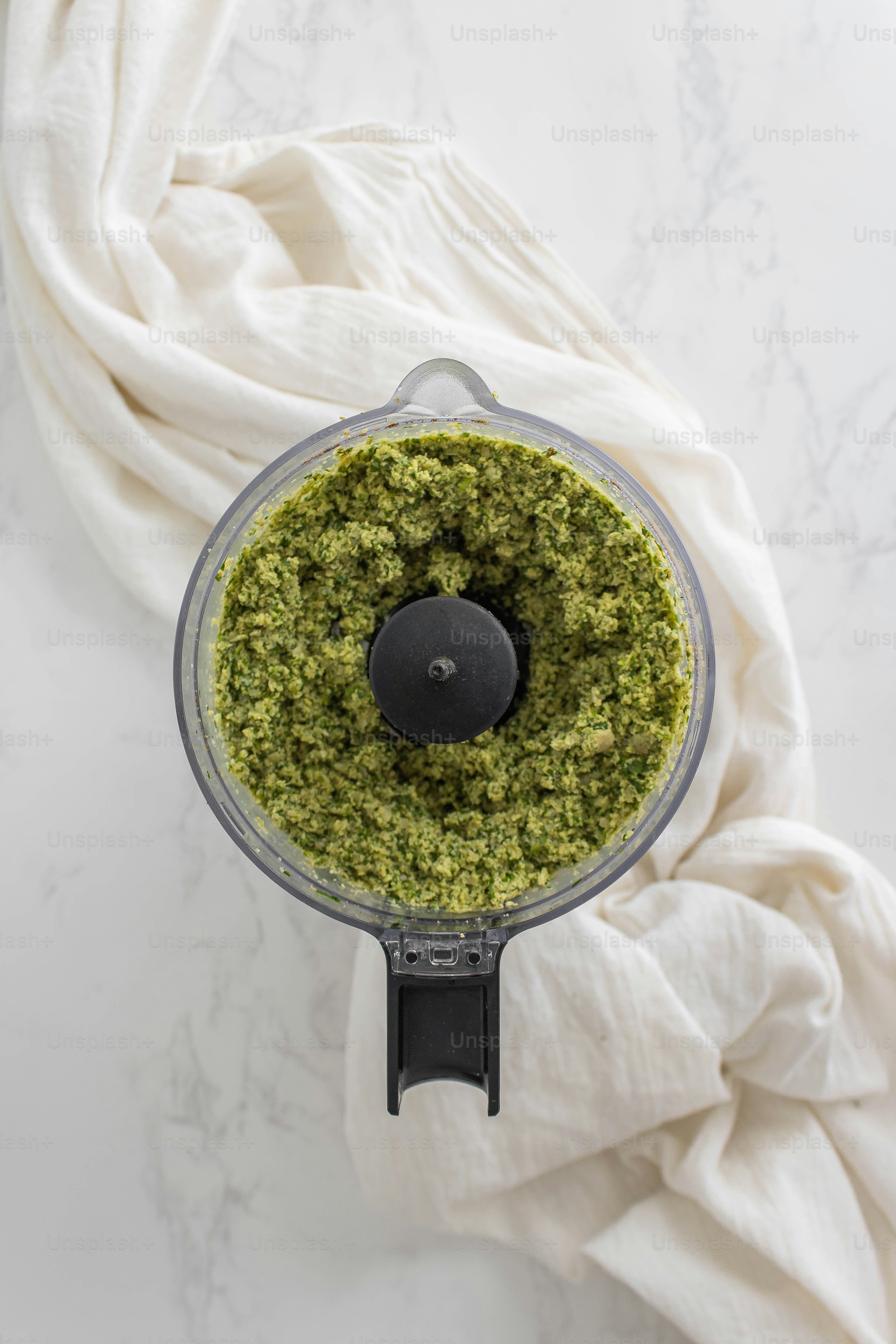 A food processor filled with pesto on top of a table photo Food Image on Unsplash