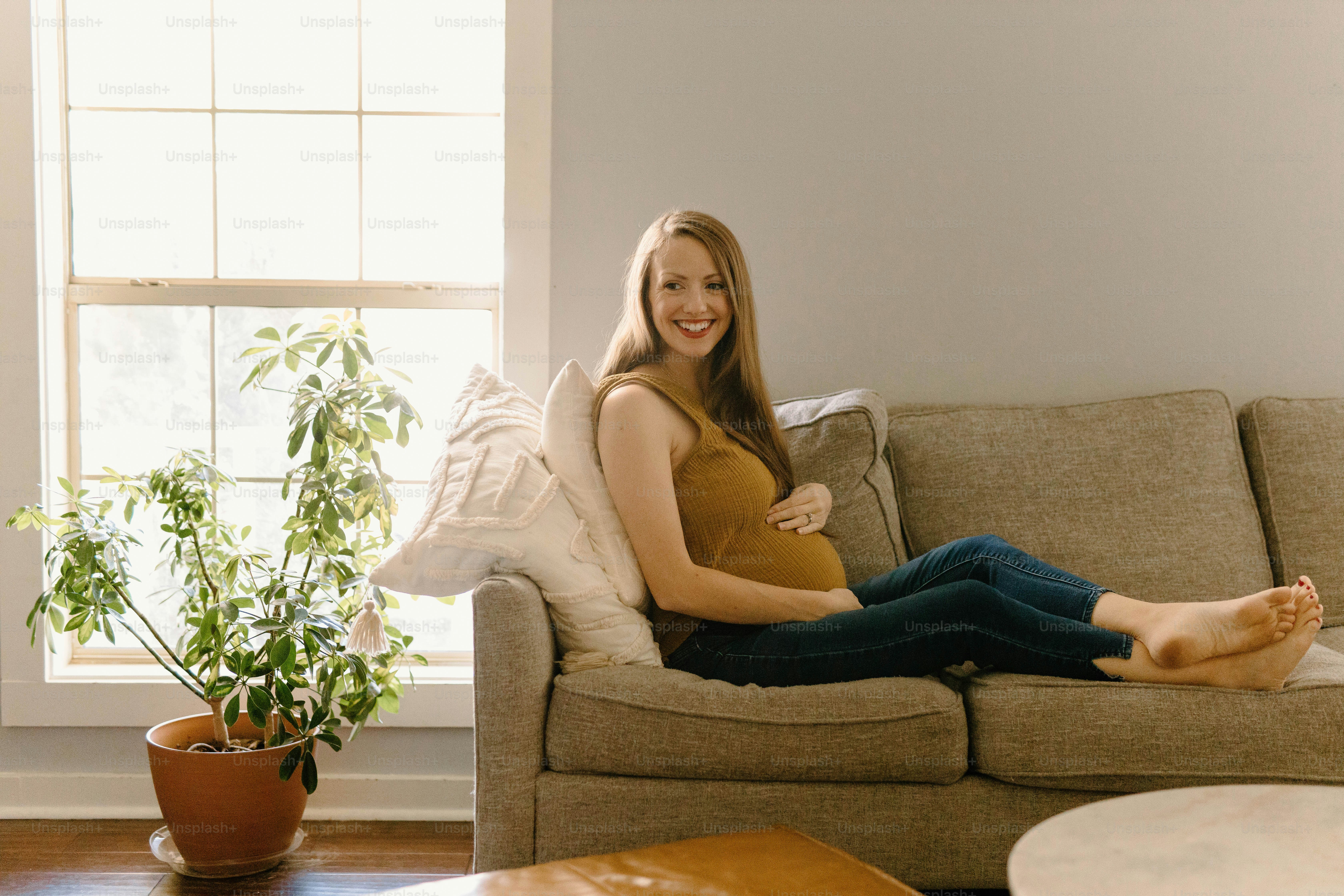 A woman sitting on a couch with her legs crossed photo Second