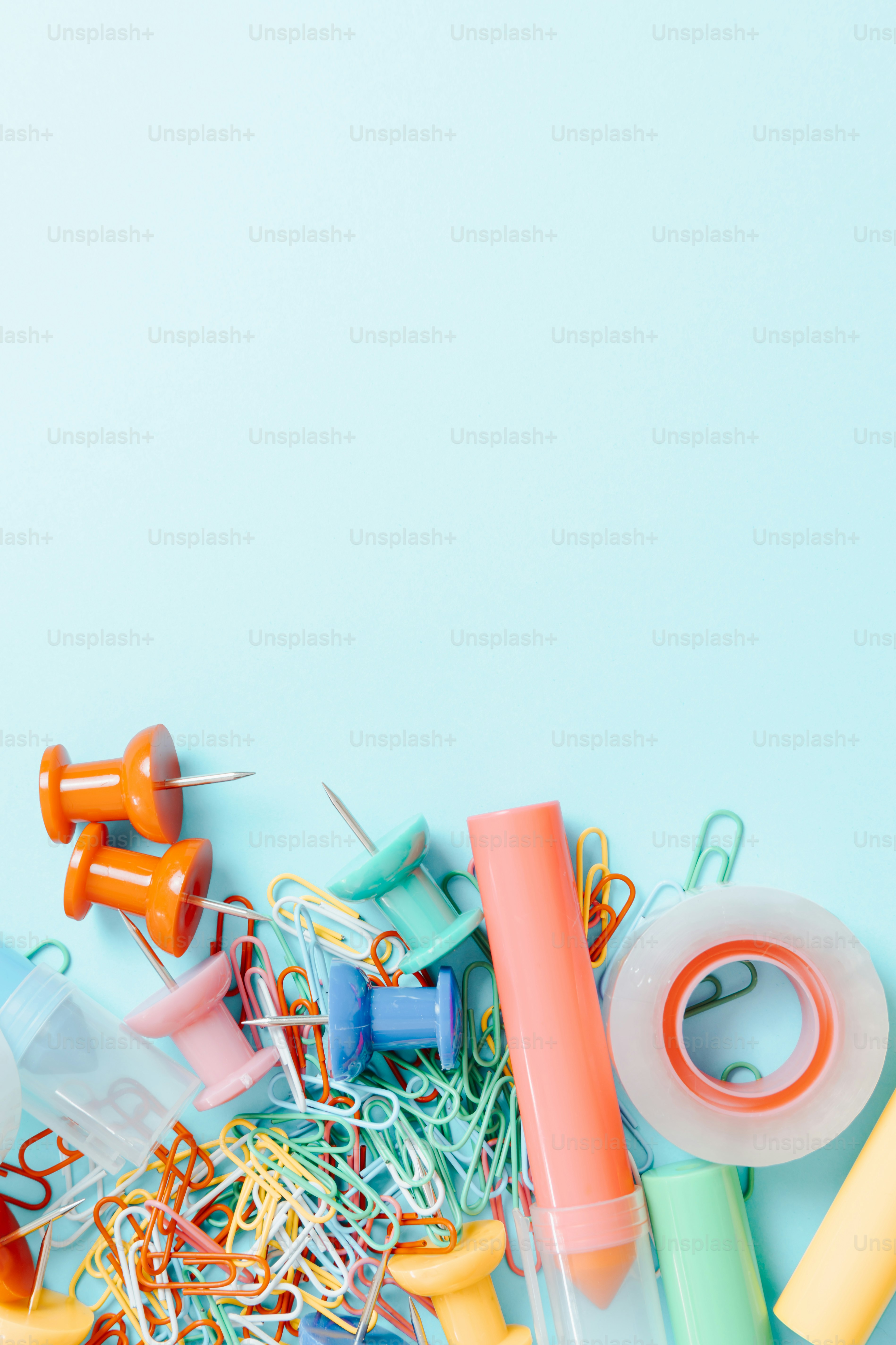 A pile of assorted craft supplies on a blue background photo Paper clip Image on Unsplash