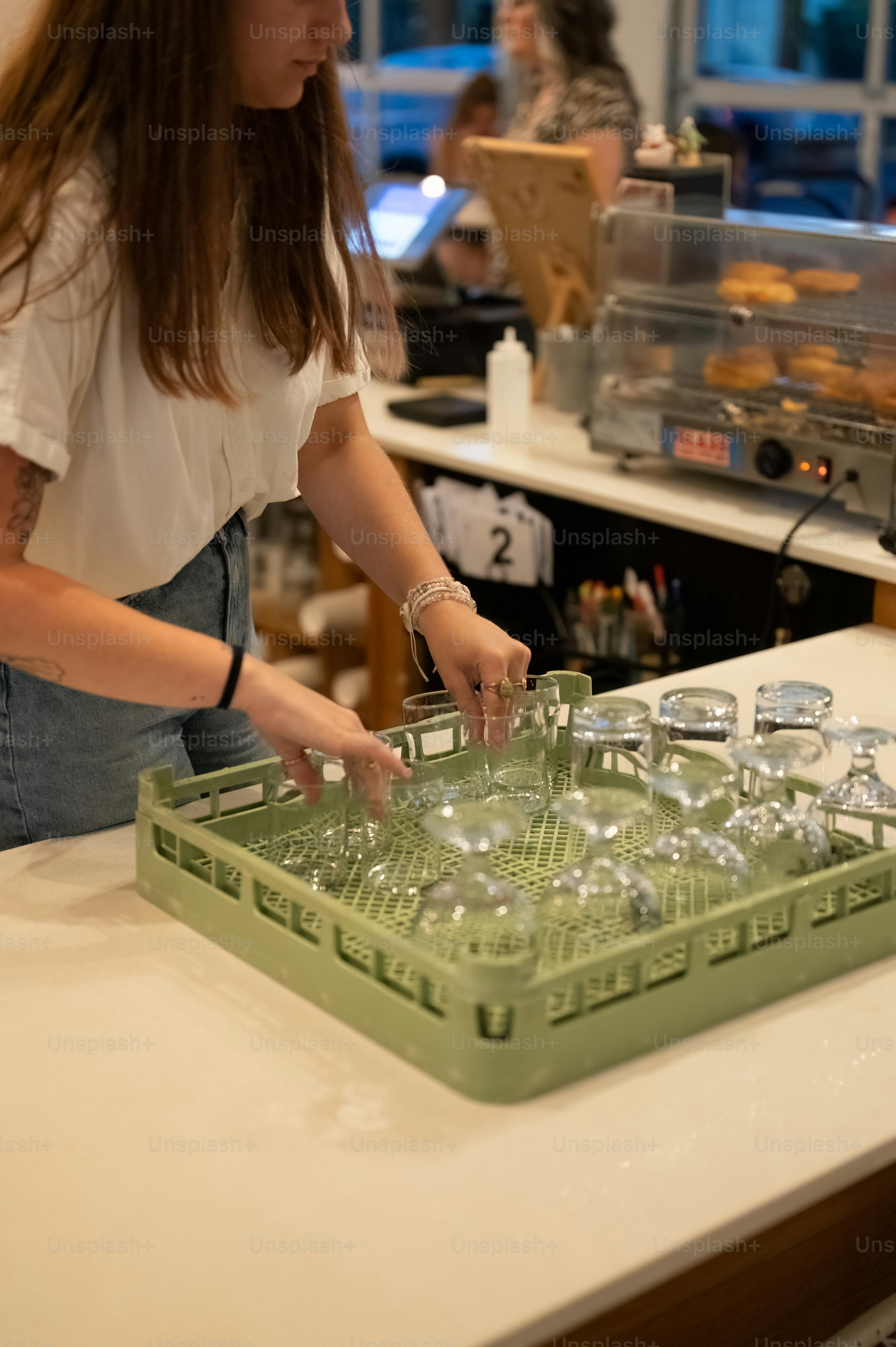 A woman is putting glasses in a dishwasher photo Grand opening Image